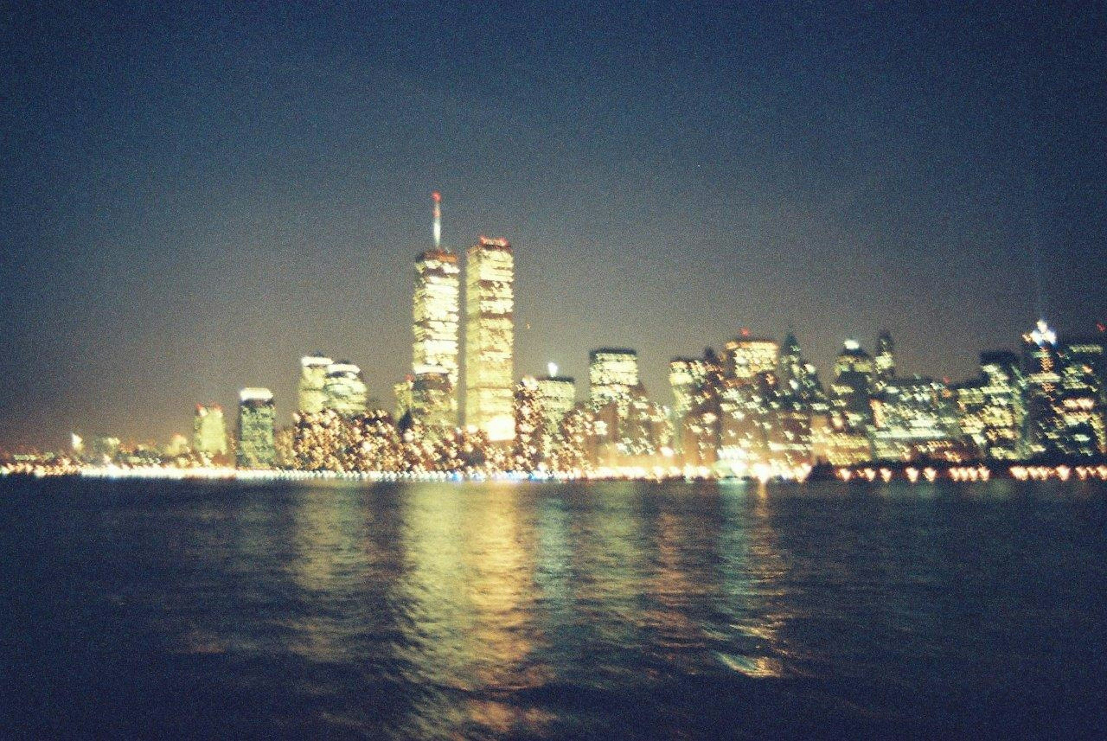 Horizonte de Nueva York de noche con reflejos en el agua