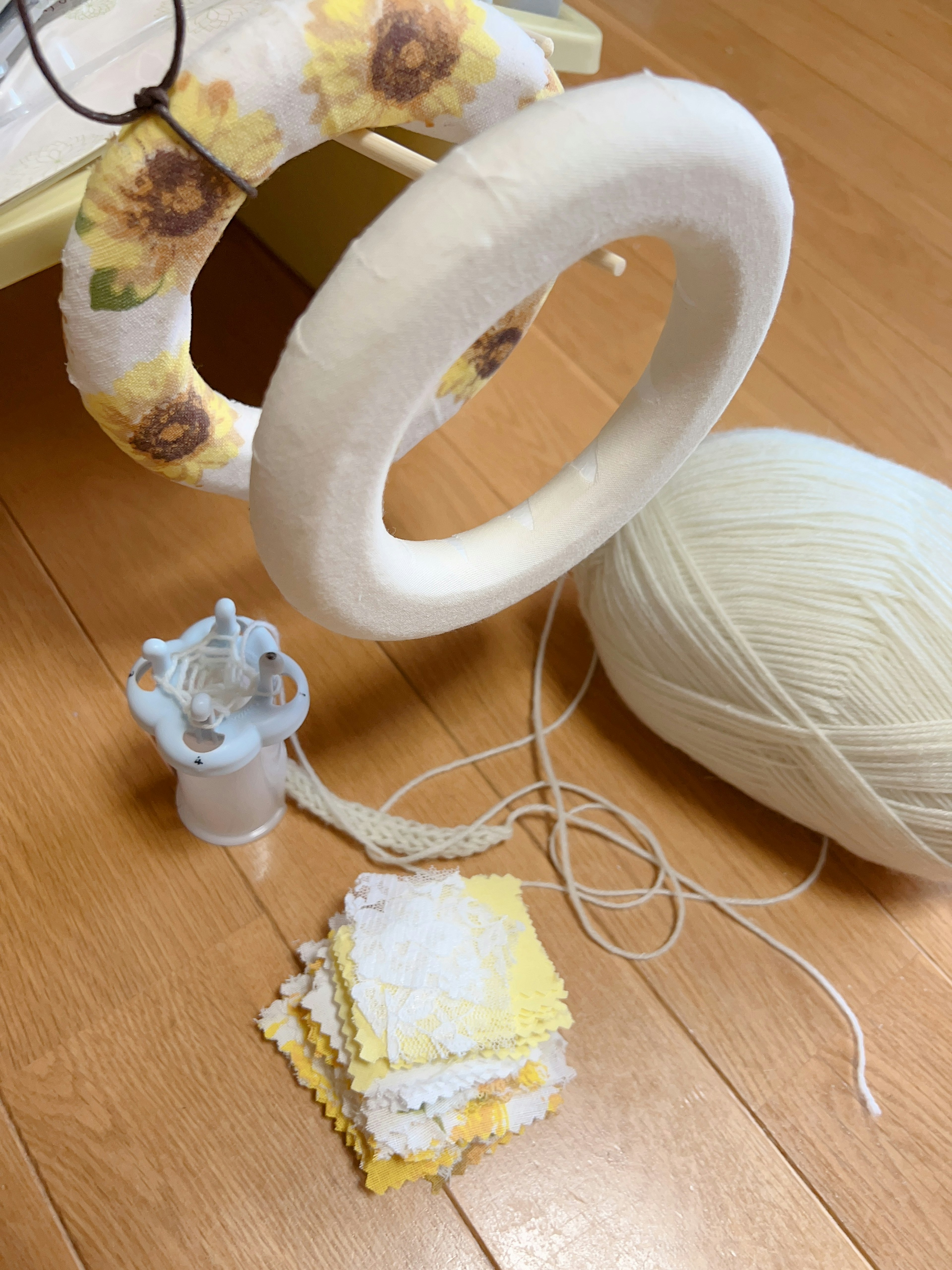 Crafting materials with a white wreath and yellow floral decorations