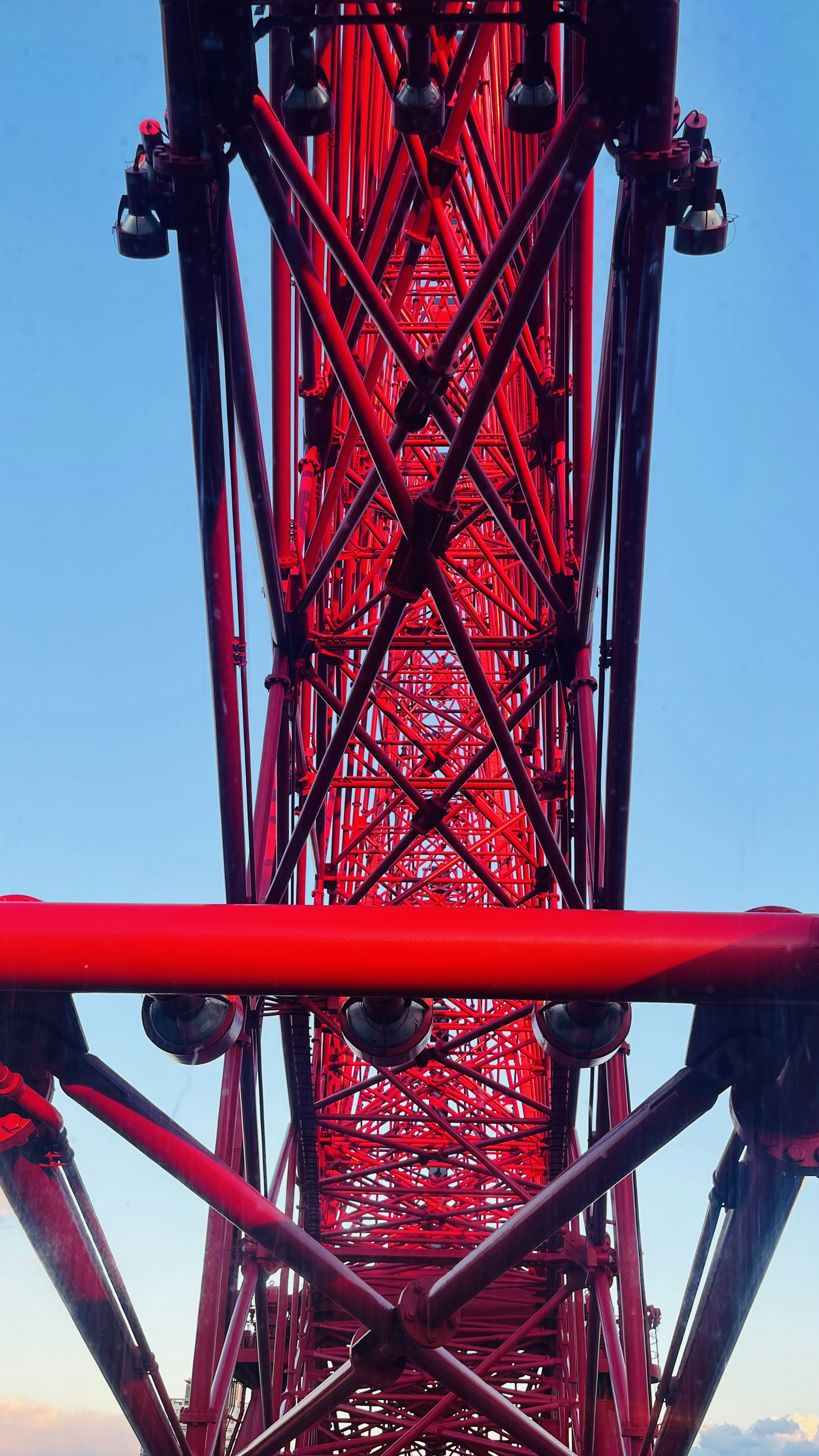 Vue d'en bas d'une grande roue rouge montrant sa structure