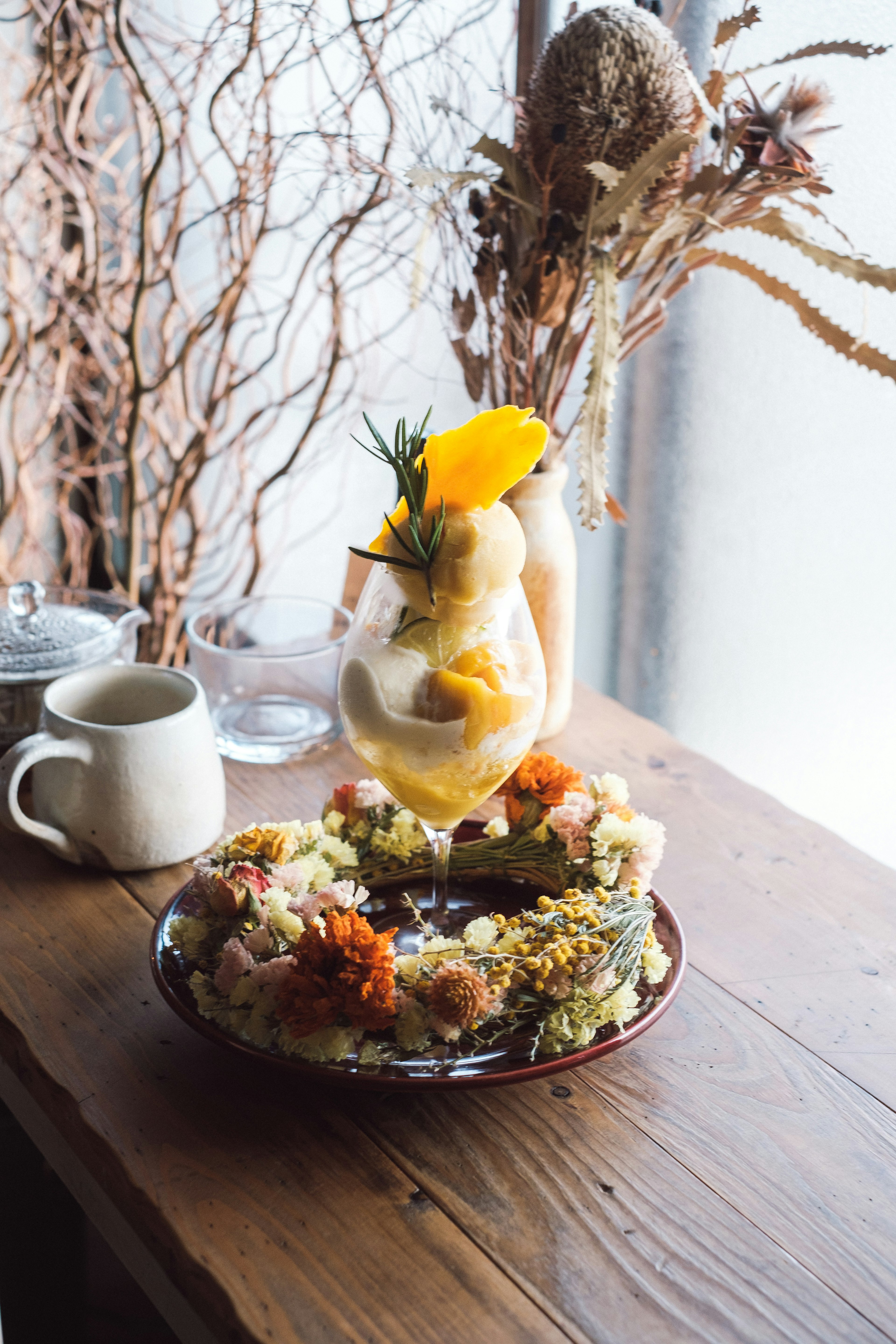 Une assiette de dessert aux fruits joliment disposée et un verre de boisson sur une table en bois