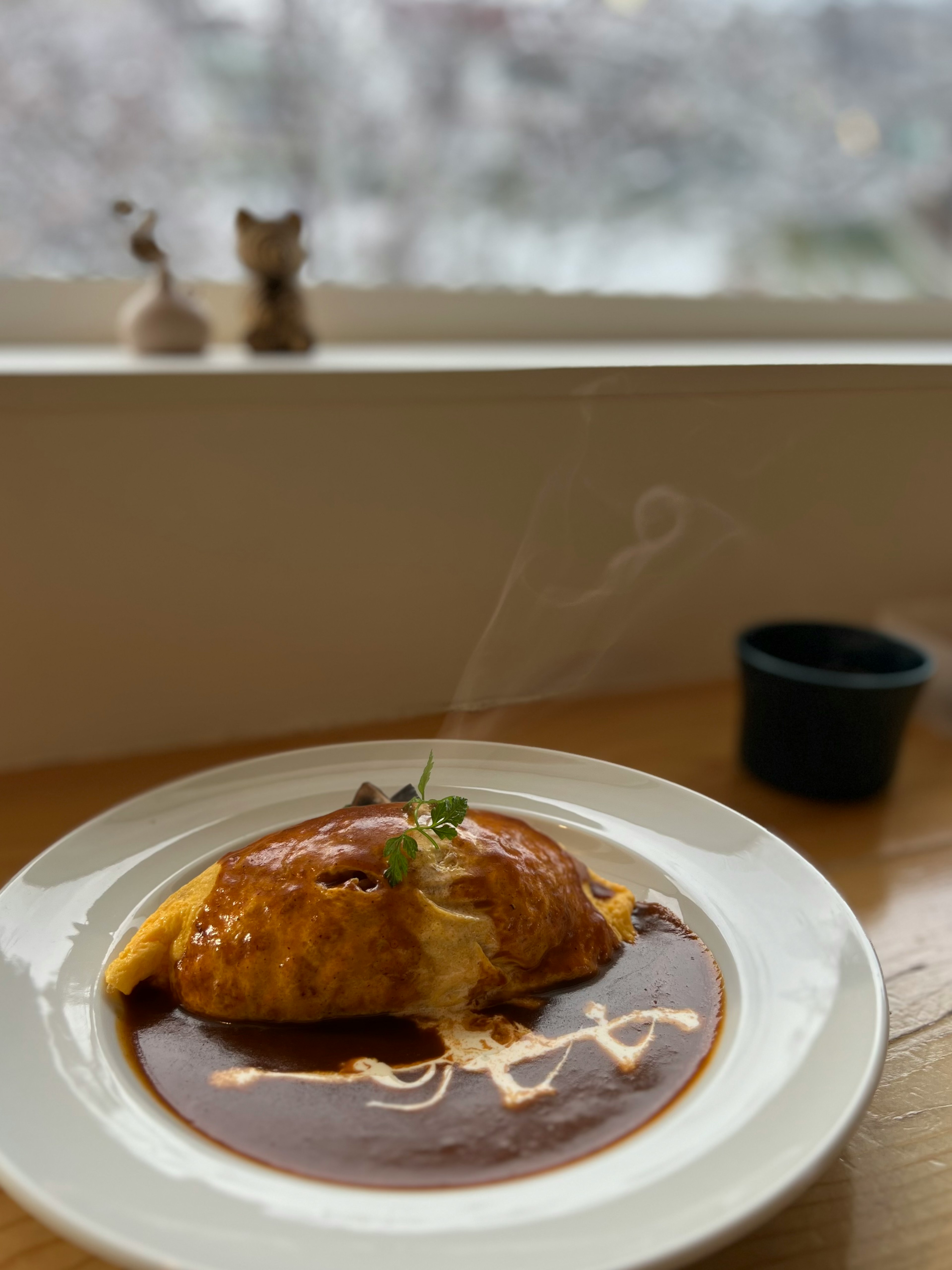 맛있는 오믈렛 라이스가 담긴 접시 위에 따뜻한 소스와 올라오는 김