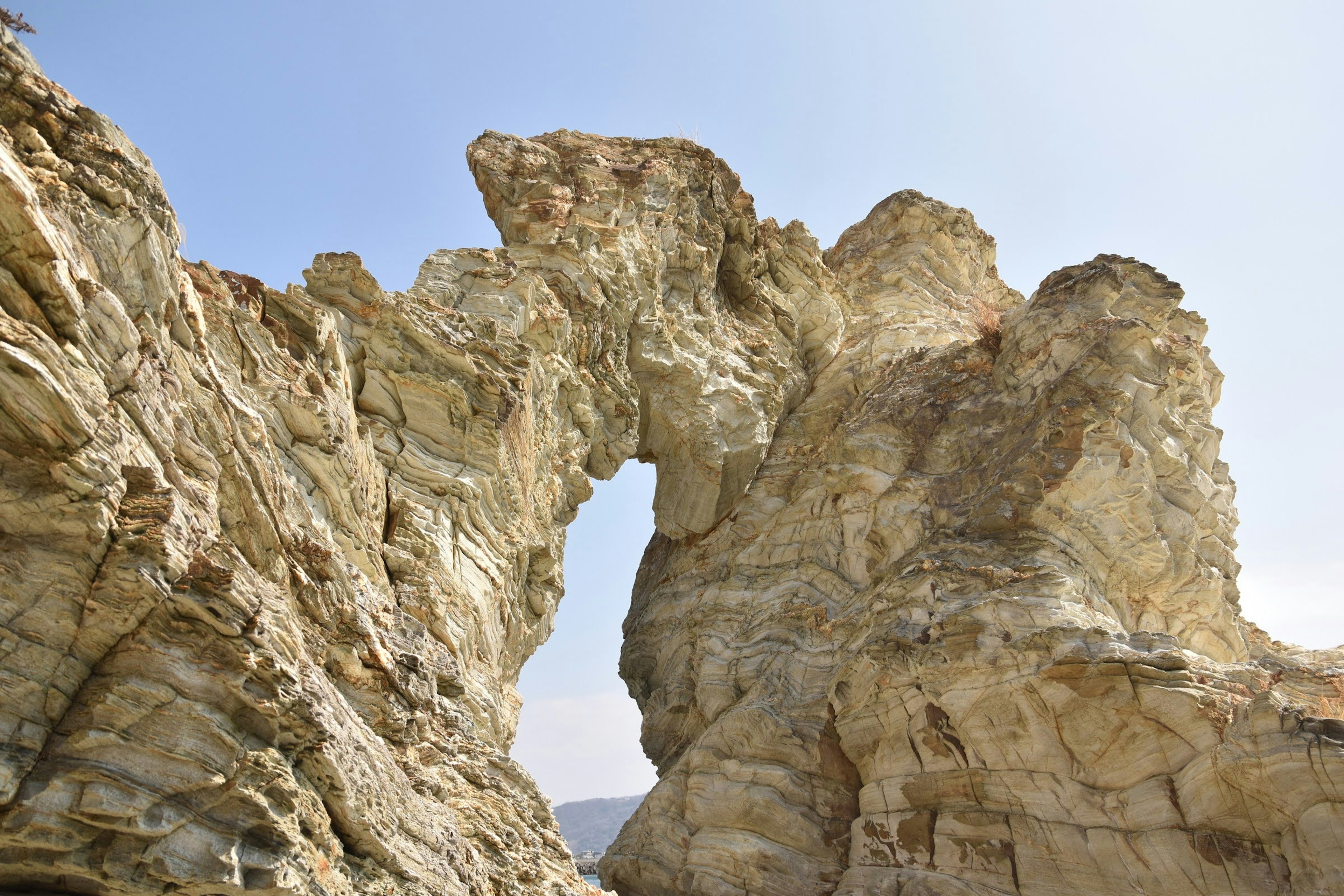 Formazione rocciosa naturale con un arco contro un cielo blu