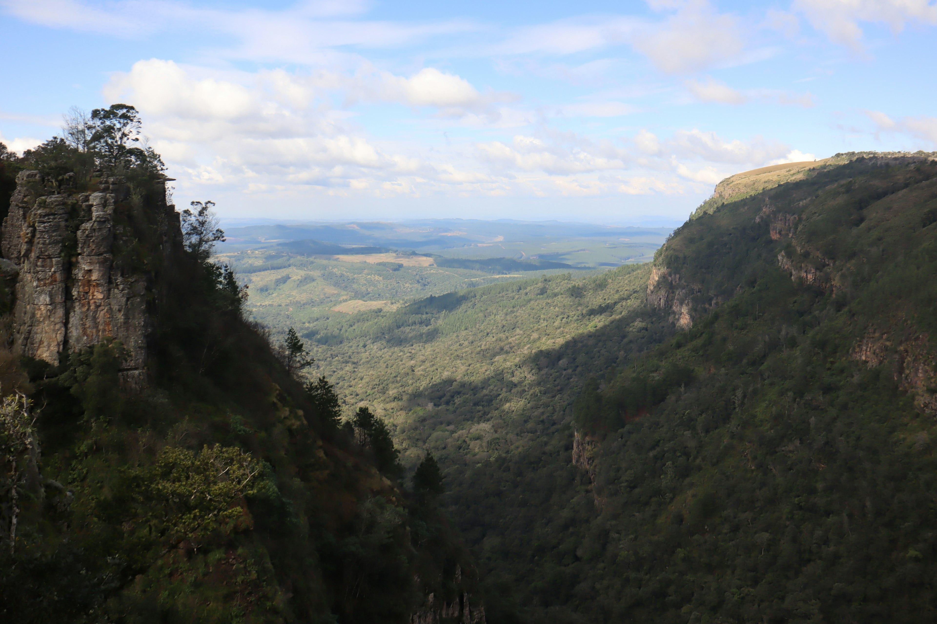 Vallée expansive avec des forêts verdoyantes et des collines lointaines