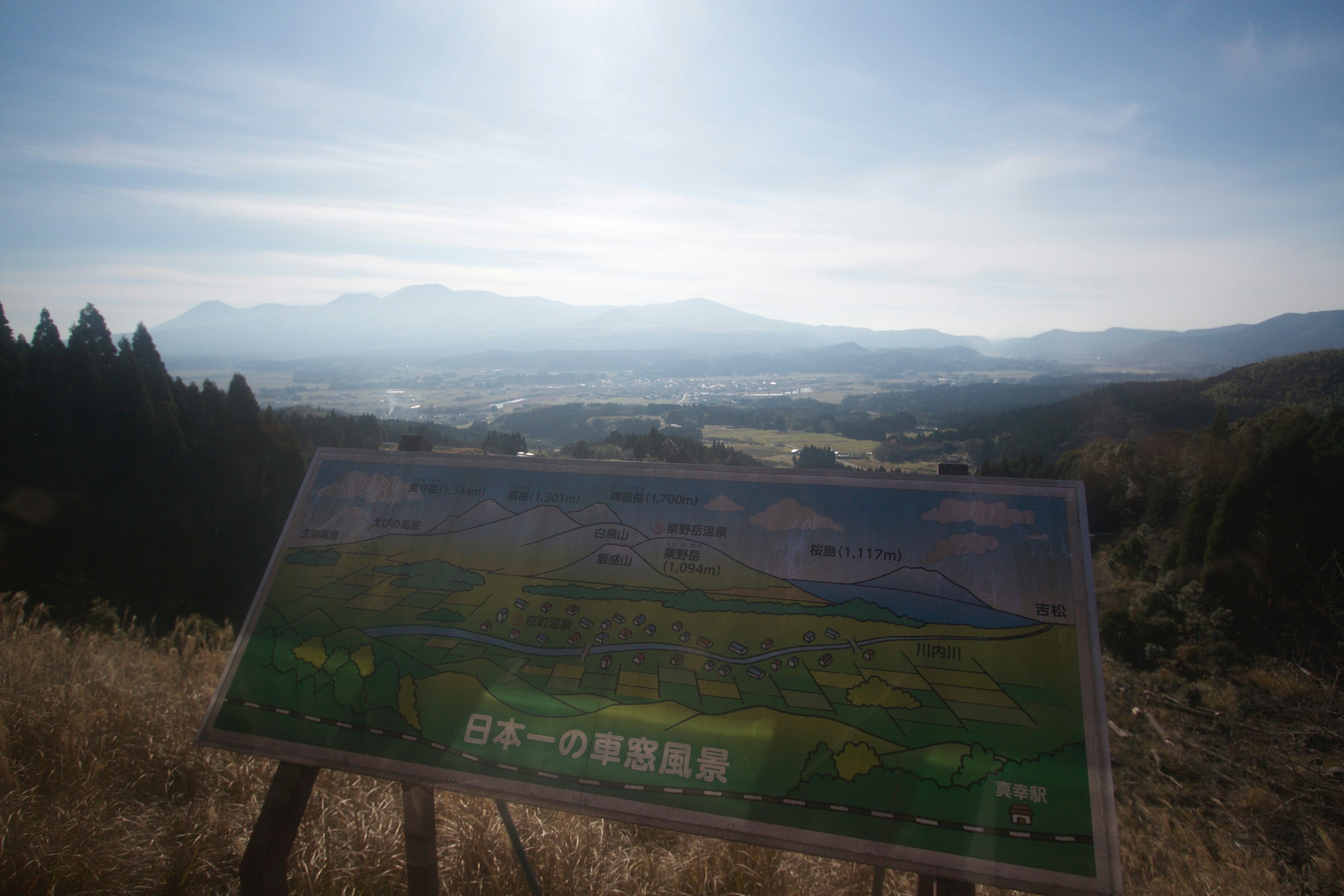 Landschaftsansicht mit einem Schild und Bergen im Hintergrund