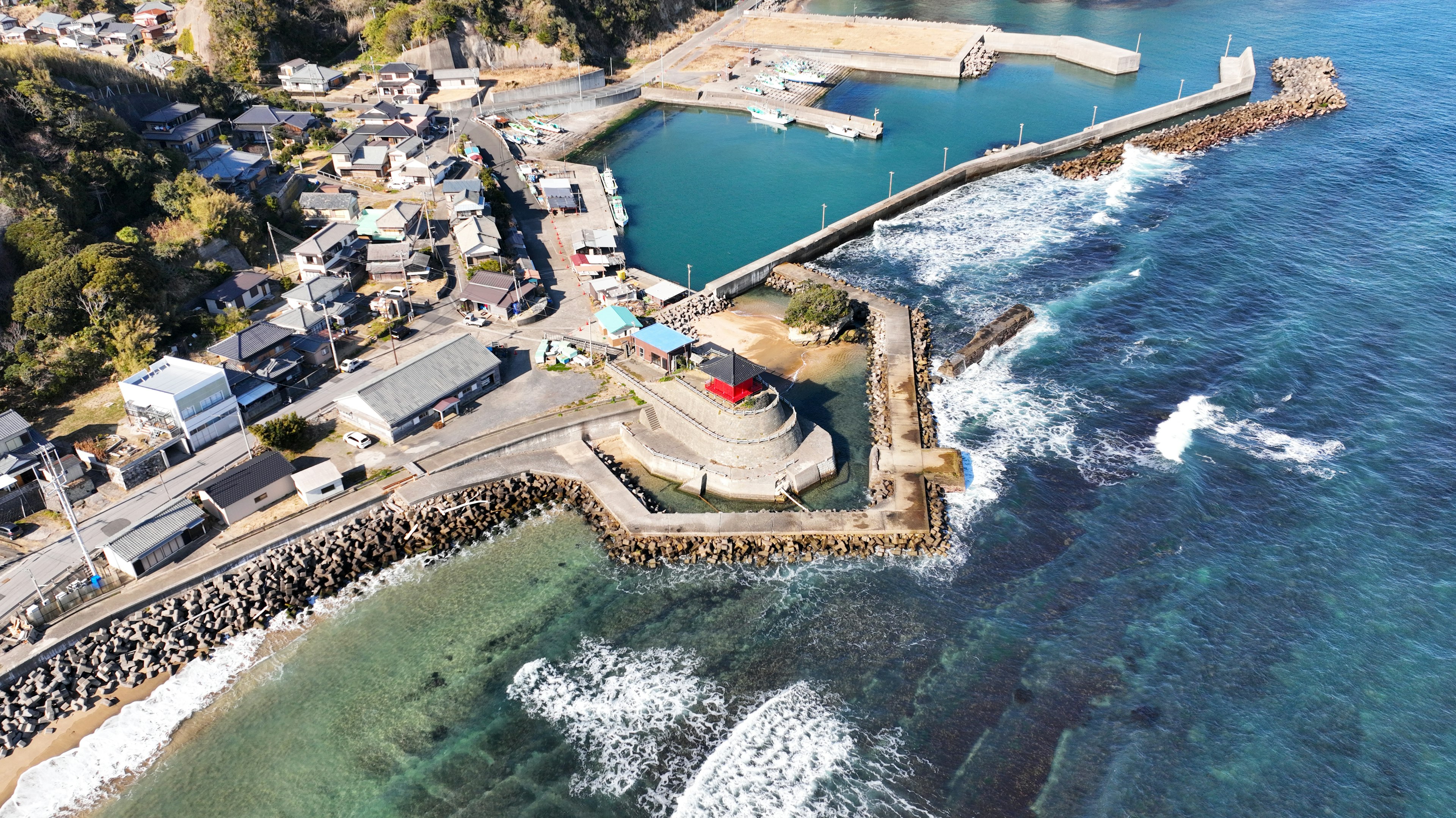 Aerial view of a coastal town featuring a harbor and breakwater