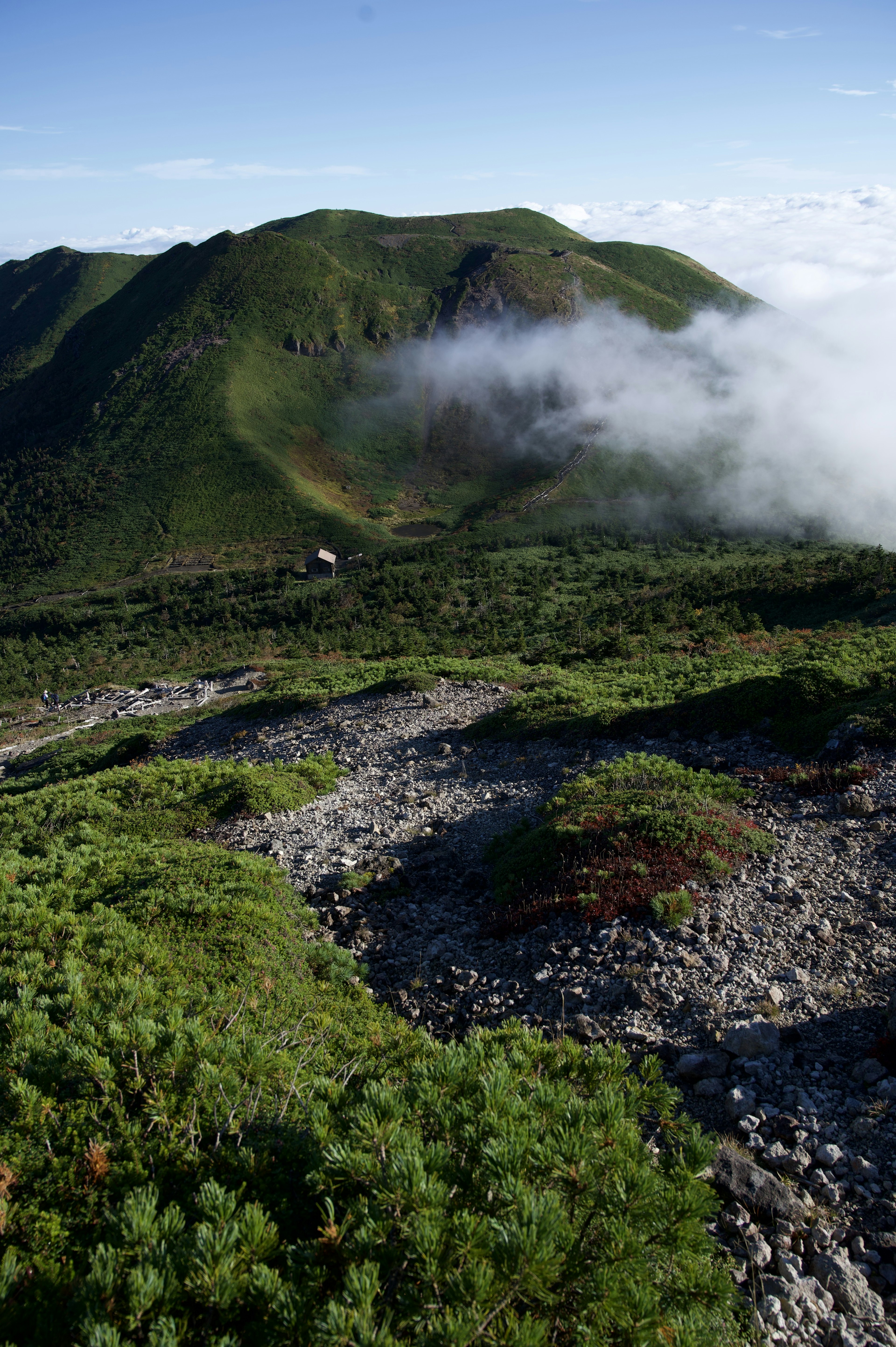 Lush green mountain landscape with clouds in the sky