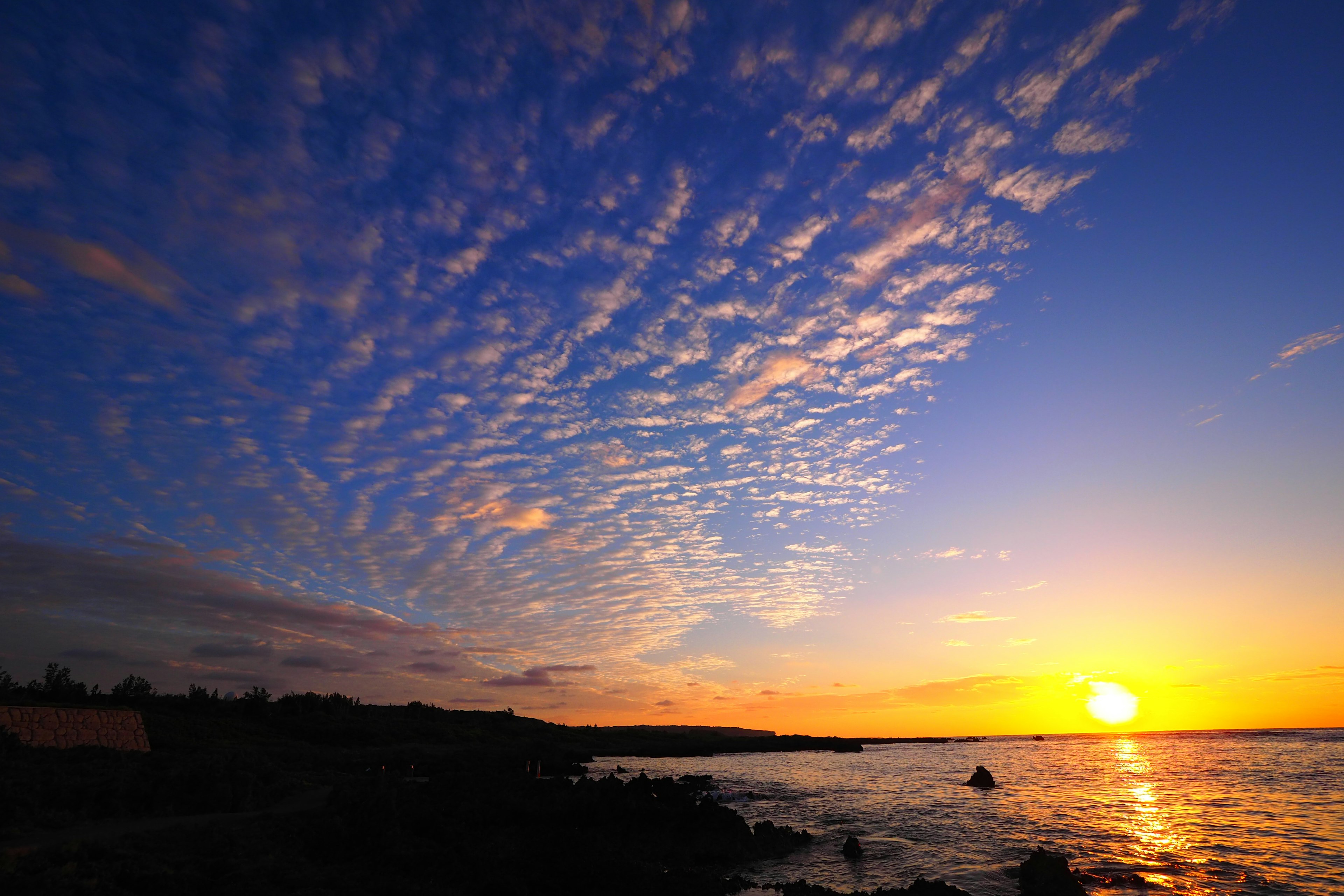 Bellissimo tramonto sull'oceano con nuvole colorate nel cielo blu