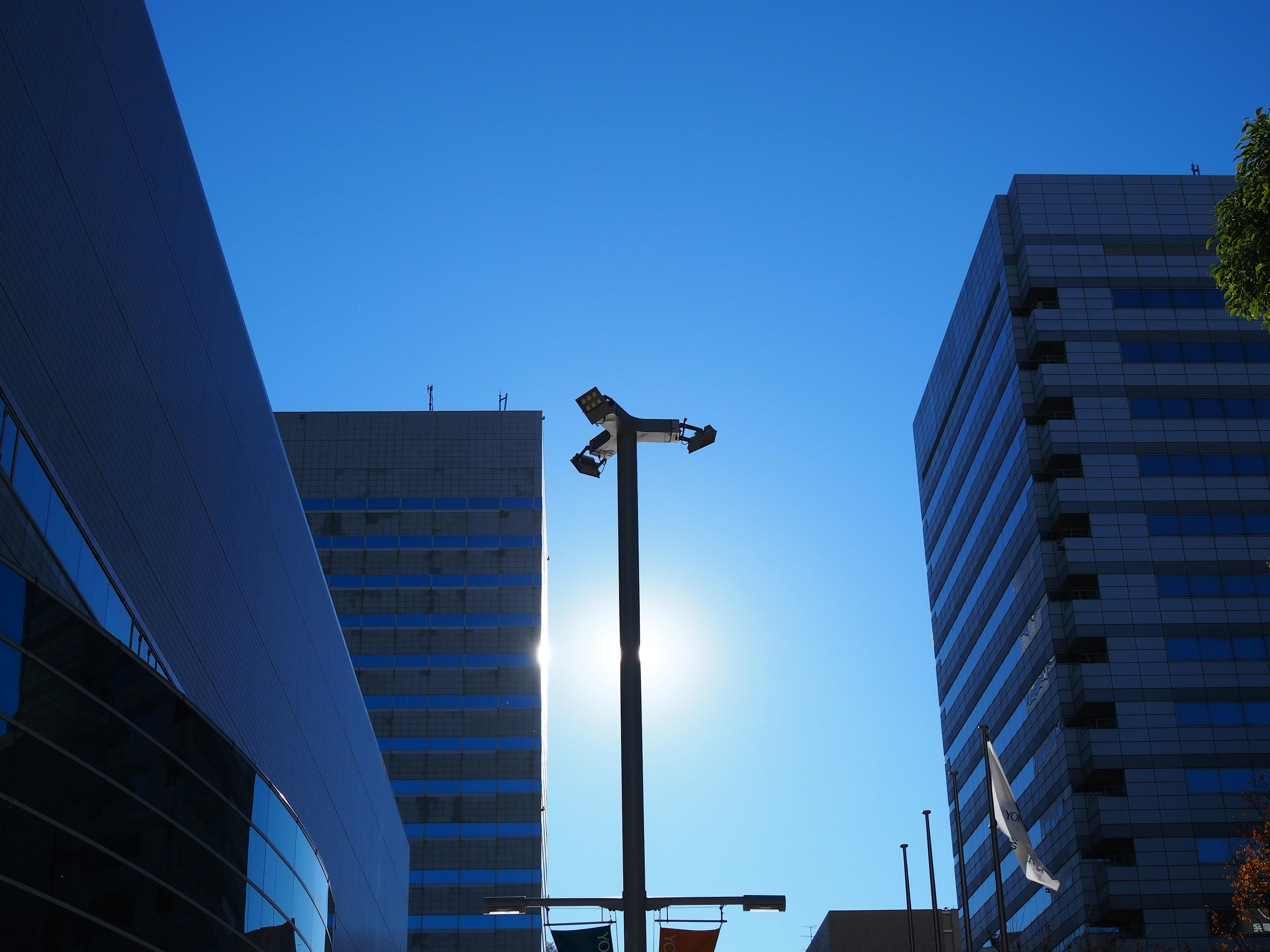 Silhouette di edifici moderni e lampione sotto un cielo blu