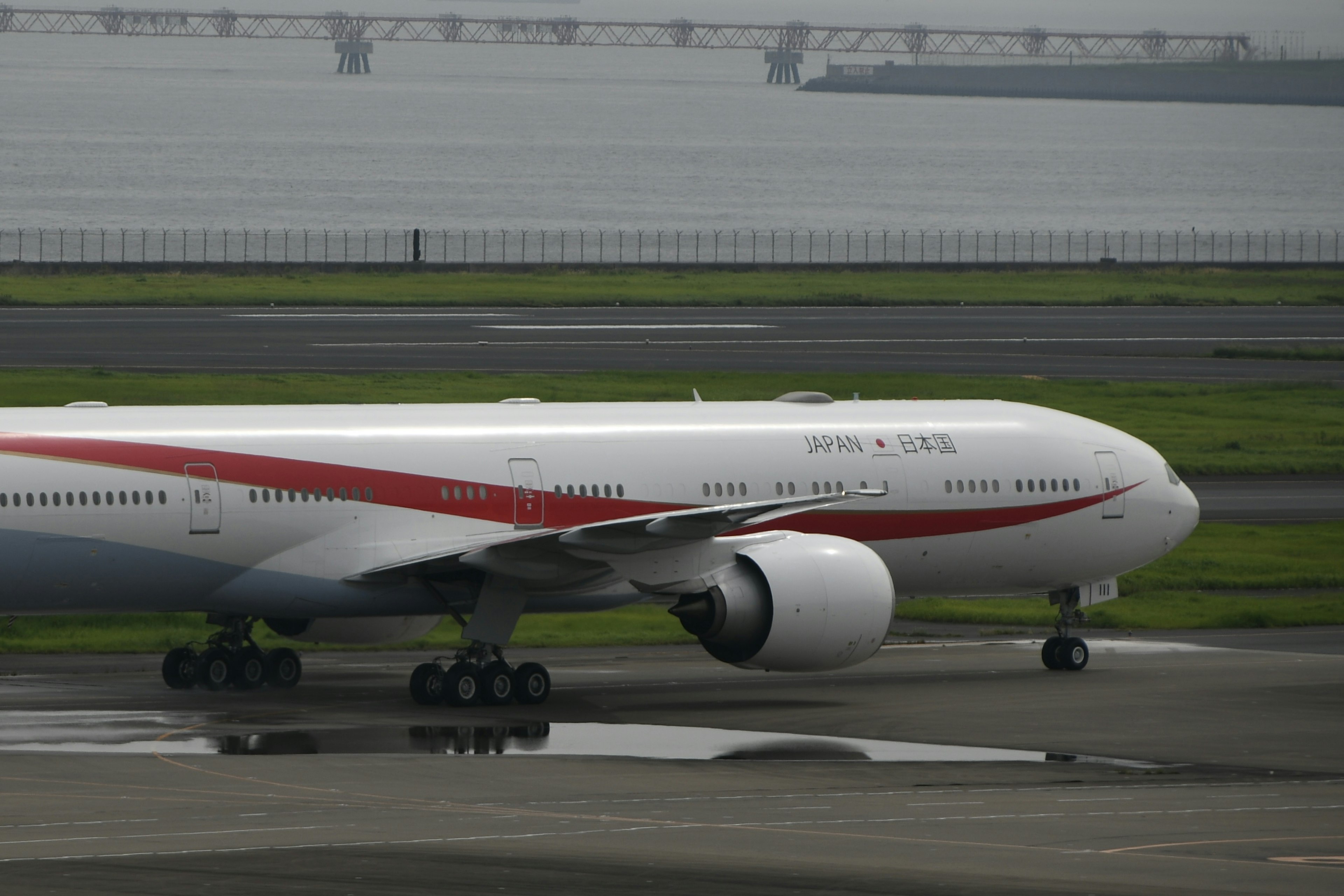 White aircraft on runway with red stripe