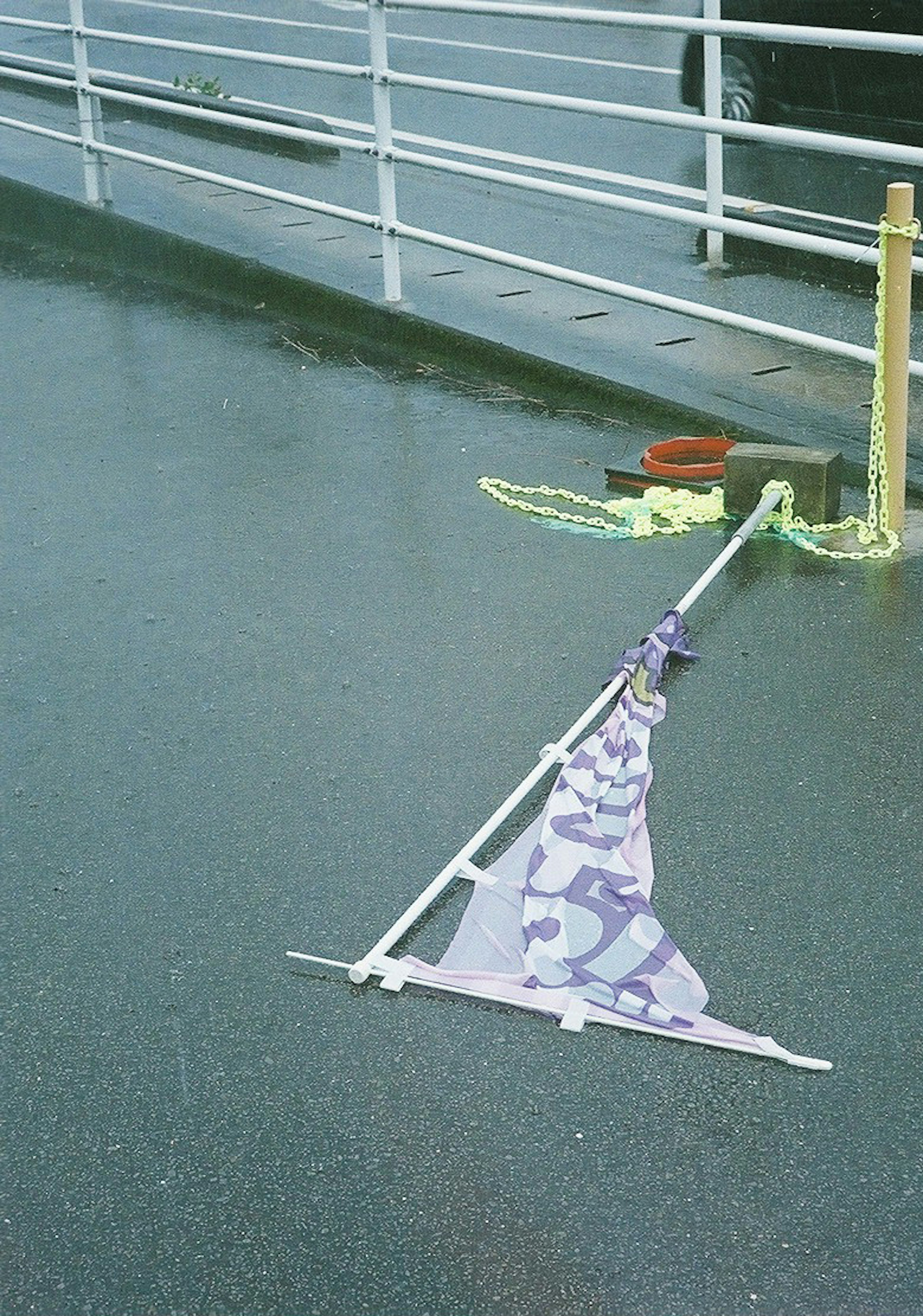 Un drapeau tombé sur un sol mouillé avec des flaques d'eau