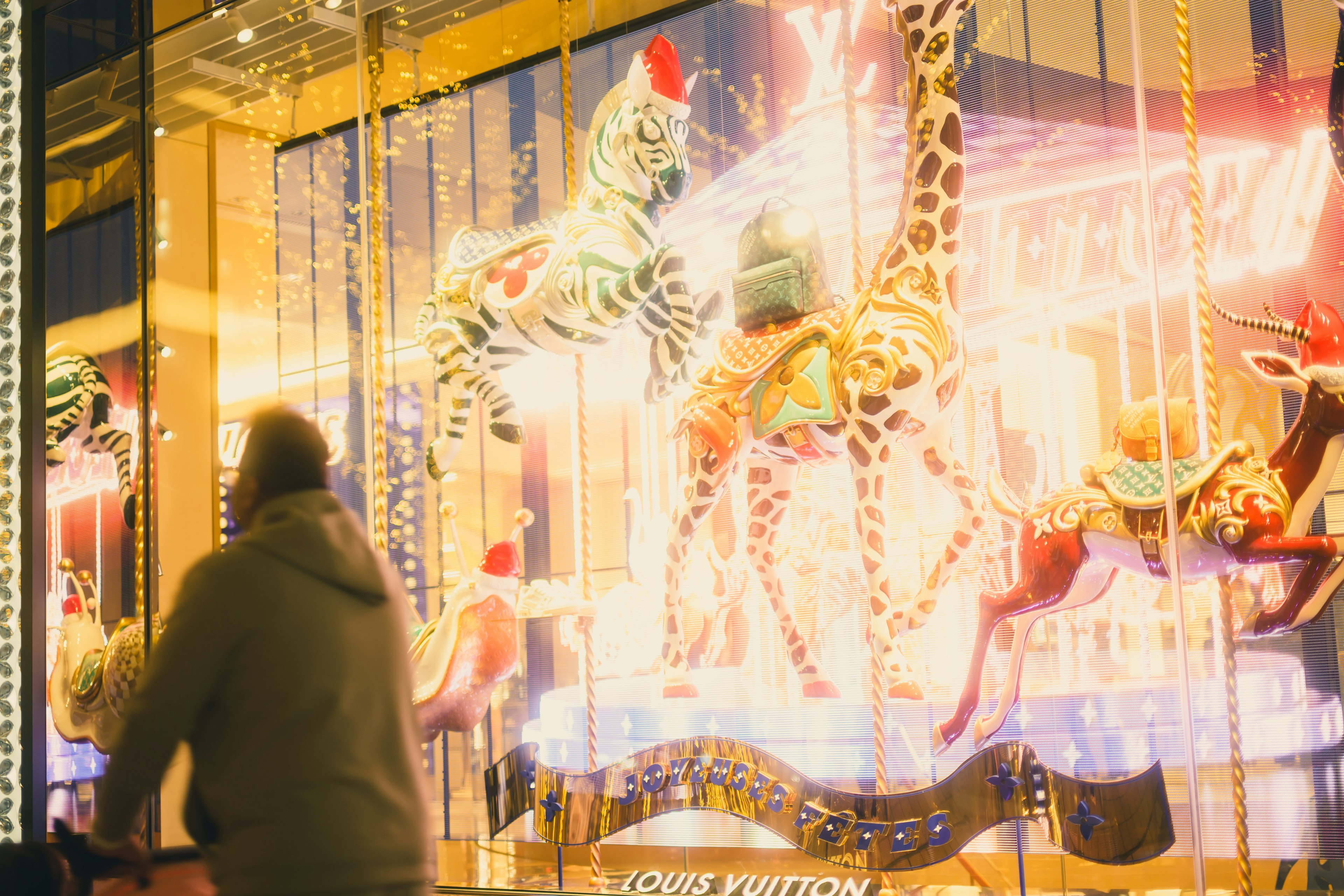 Vitrine colorée avec des chevaux de carrousel et des décorations festives