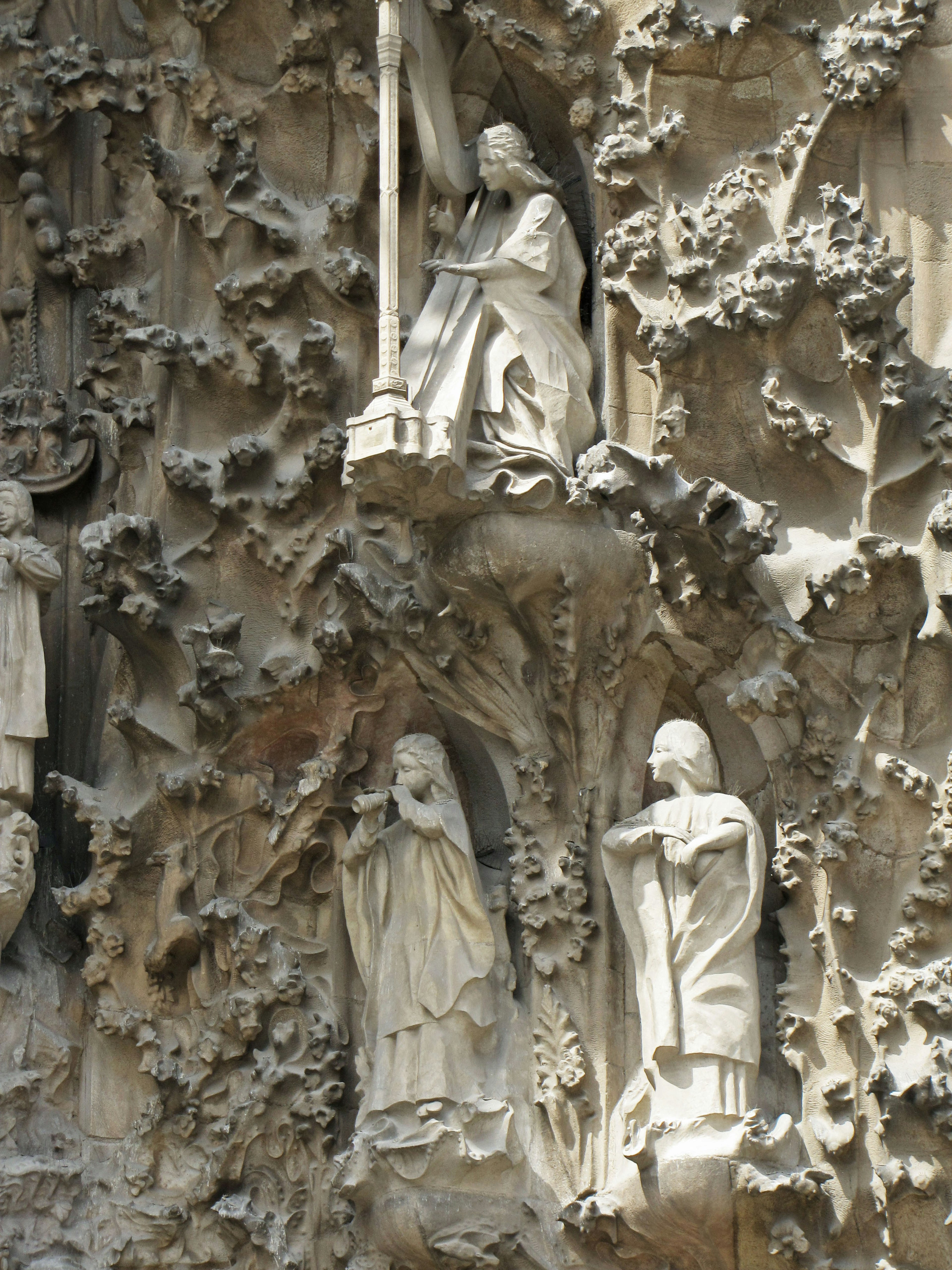 Detail of a sculpture at Sagrada Familia featuring figures of saints carved into stone