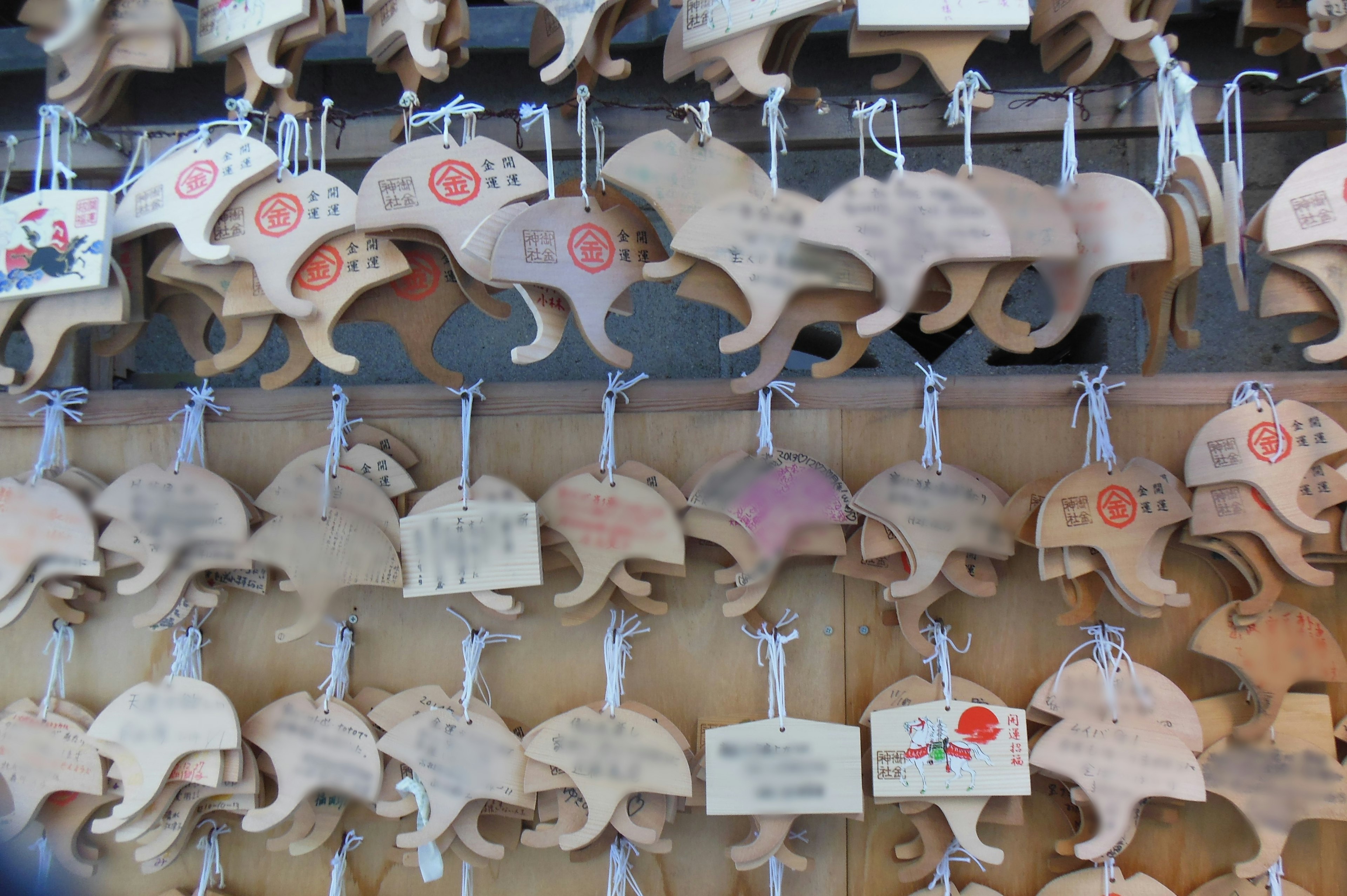 Wooden cat-shaped amulets displayed on a wall