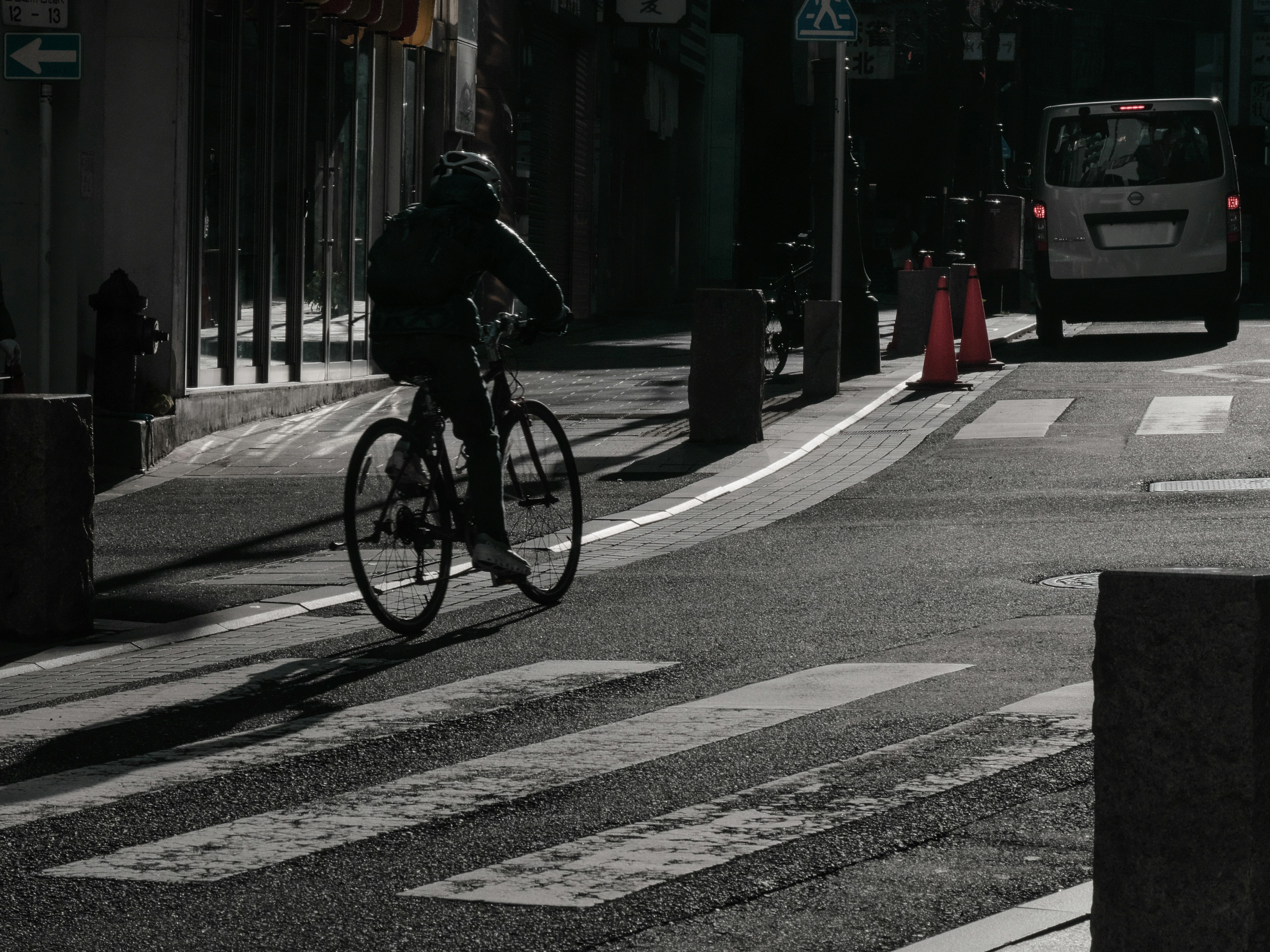 A cyclist crossing a crosswalk in an urban setting