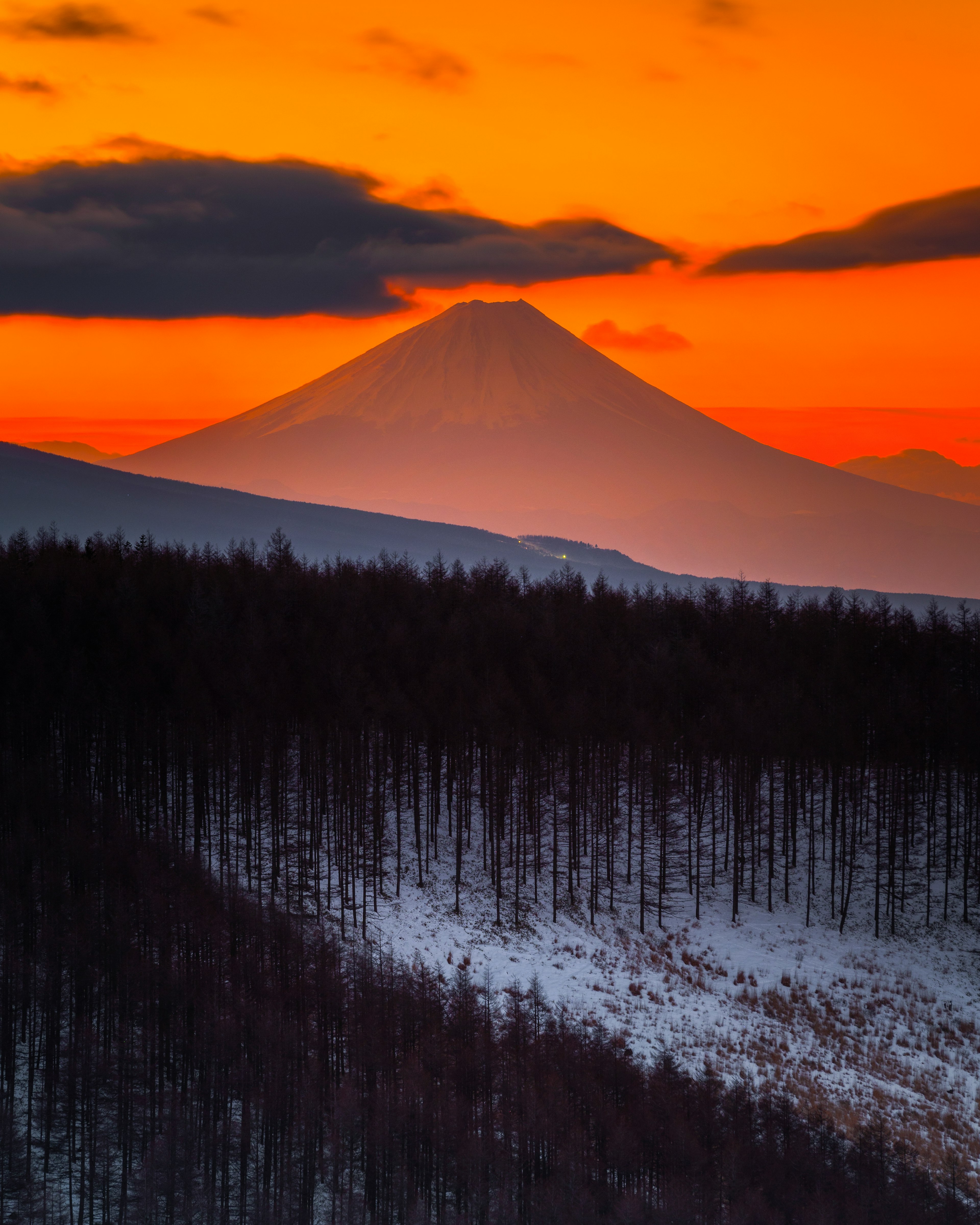 Monte Fuji silhouettato contro un vivace tramonto arancione