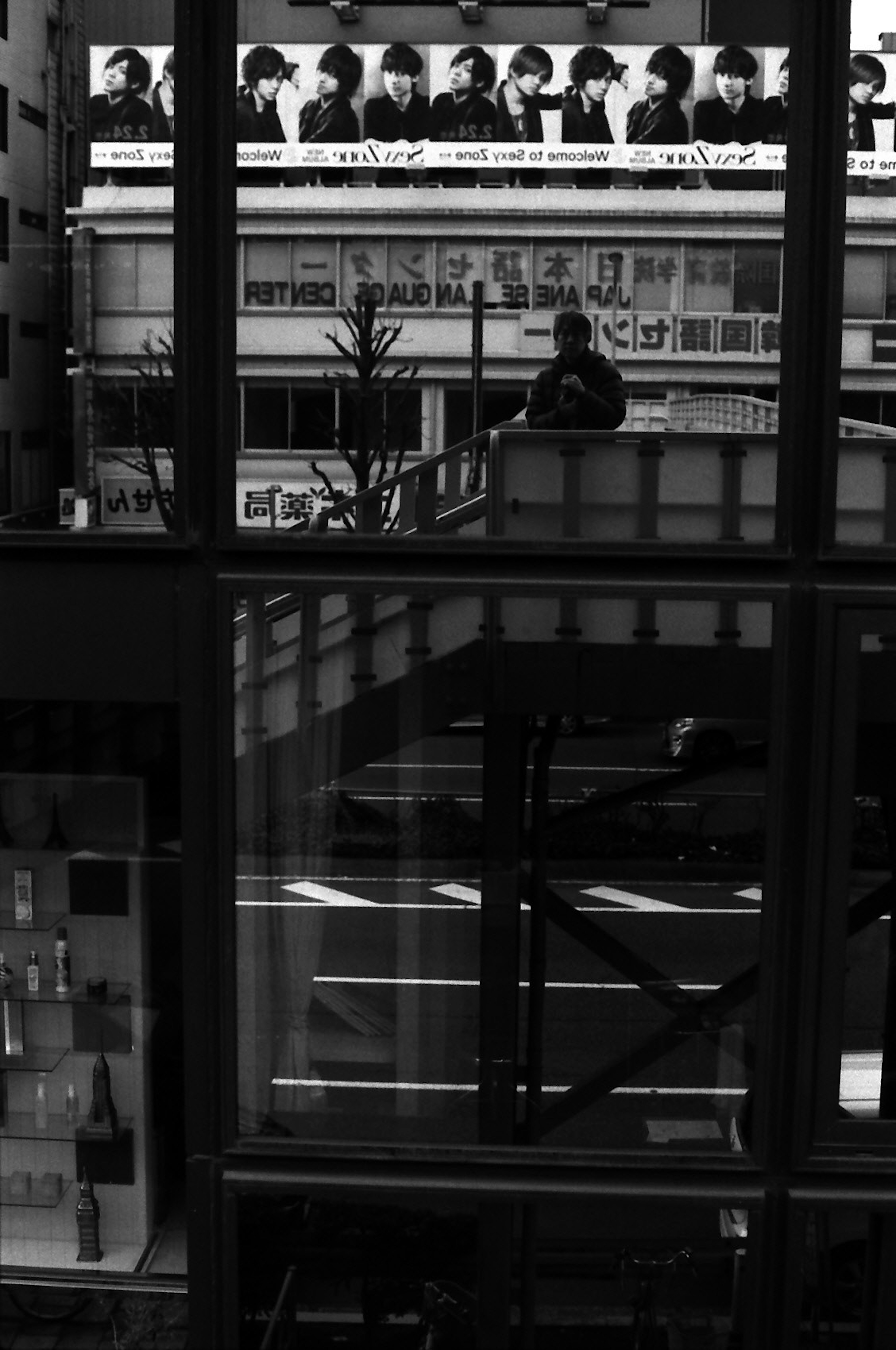 Scène urbaine avec des reflets en noir et blanc présentant une personne debout au-dessus