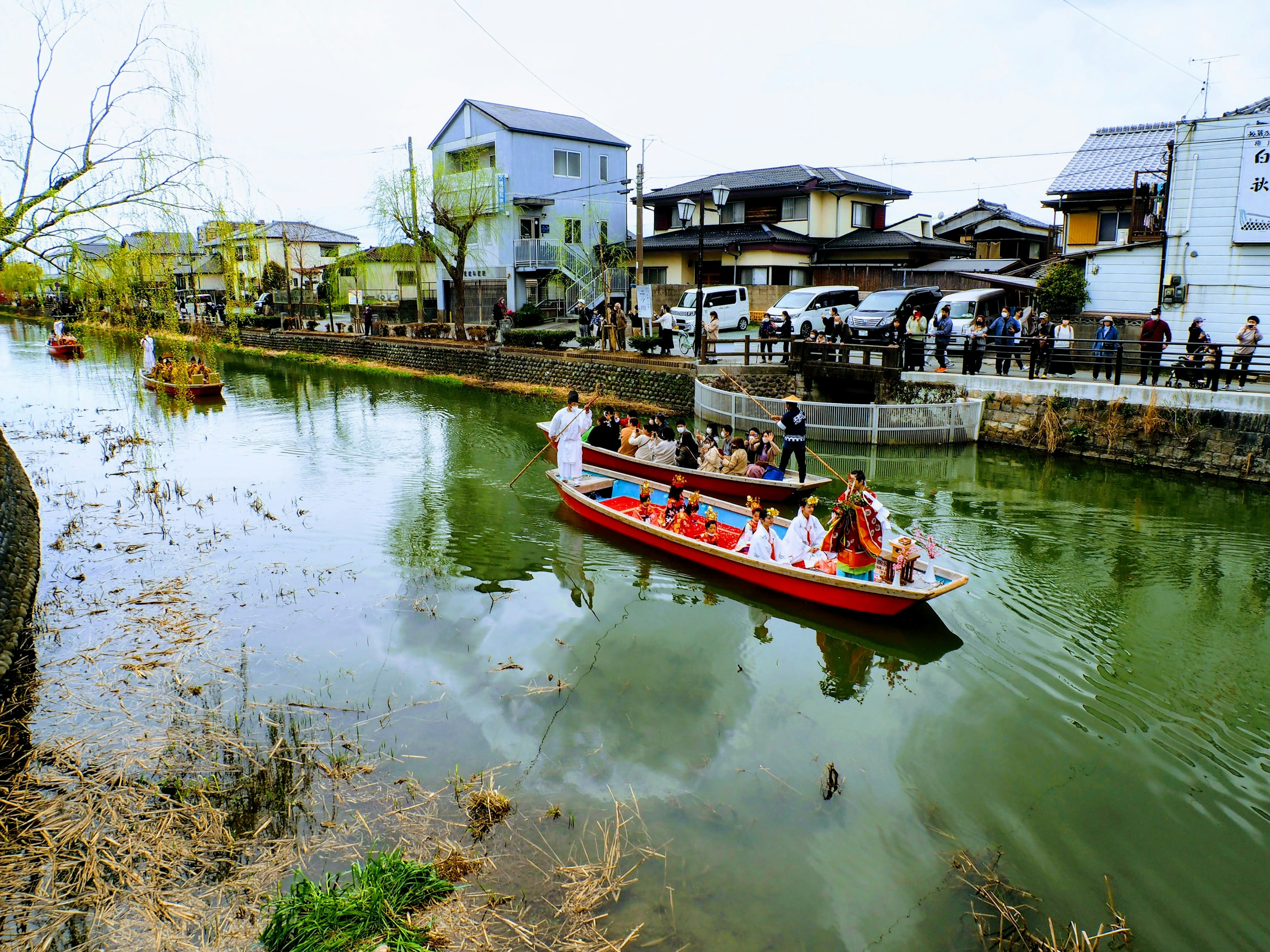 Traditional boat navigating a river with houses lining the banks