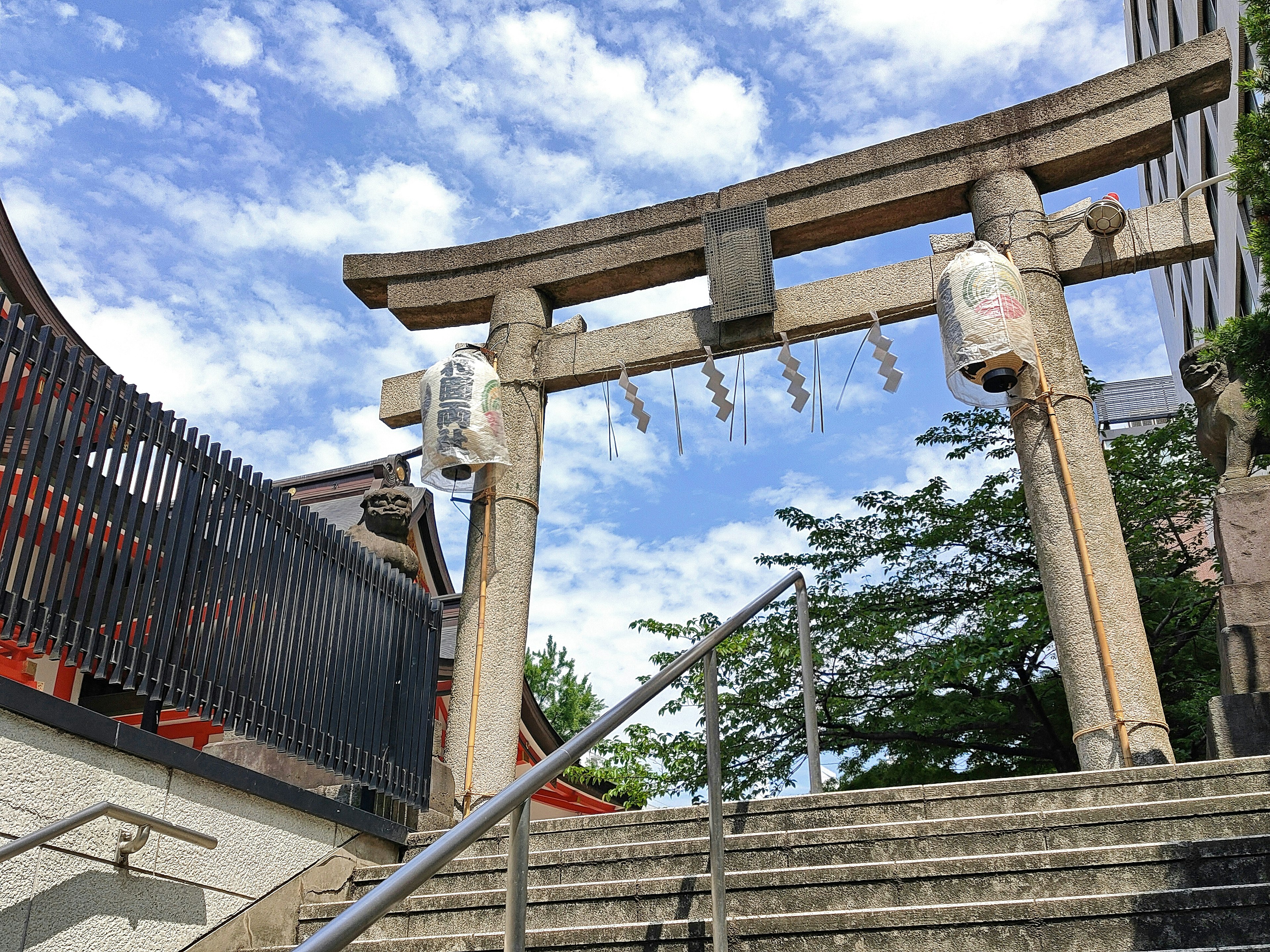 Puerta torii tradicional y escaleras bajo un cielo azul