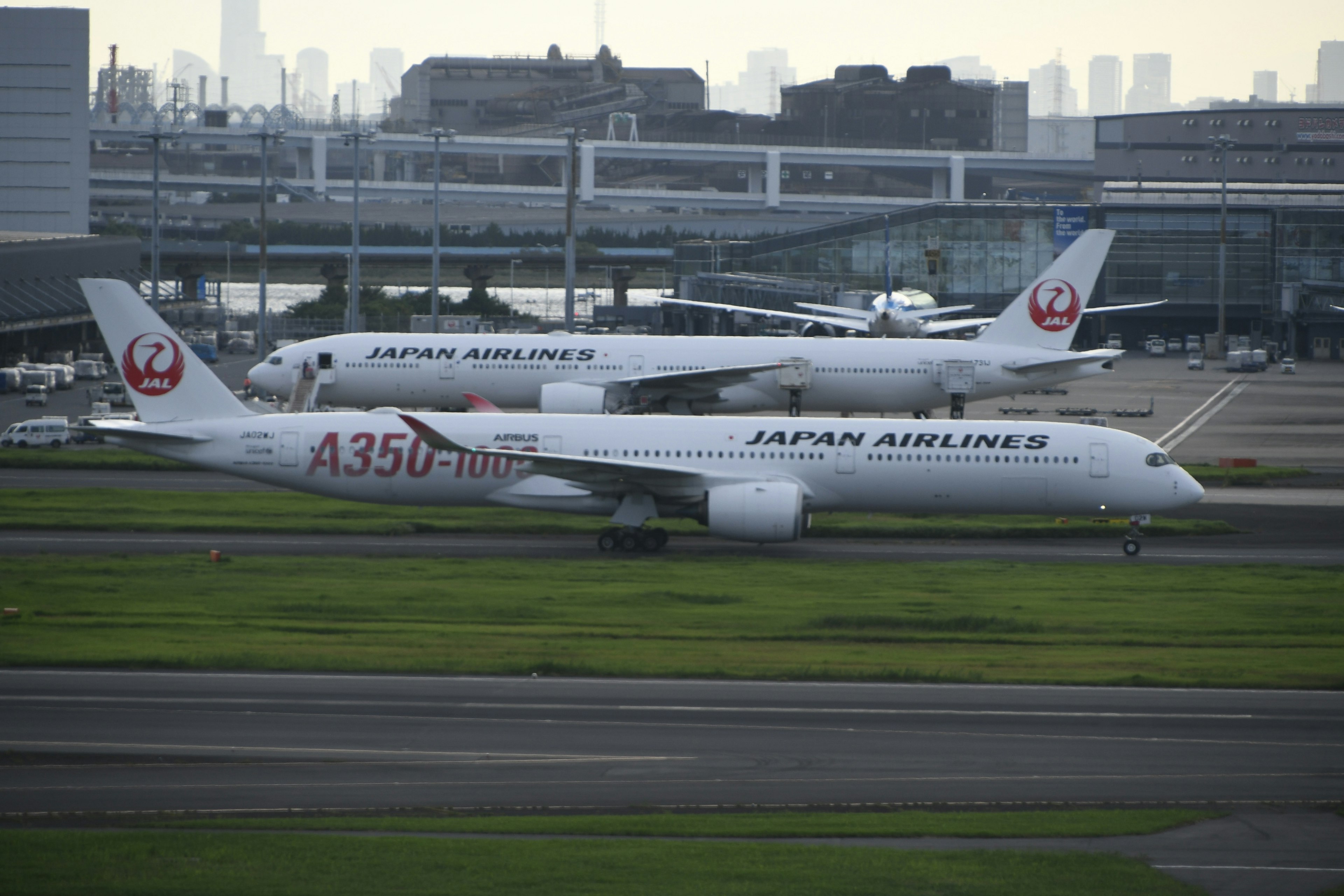 日本航空のA350とBoeing747が空港で滑走する様子