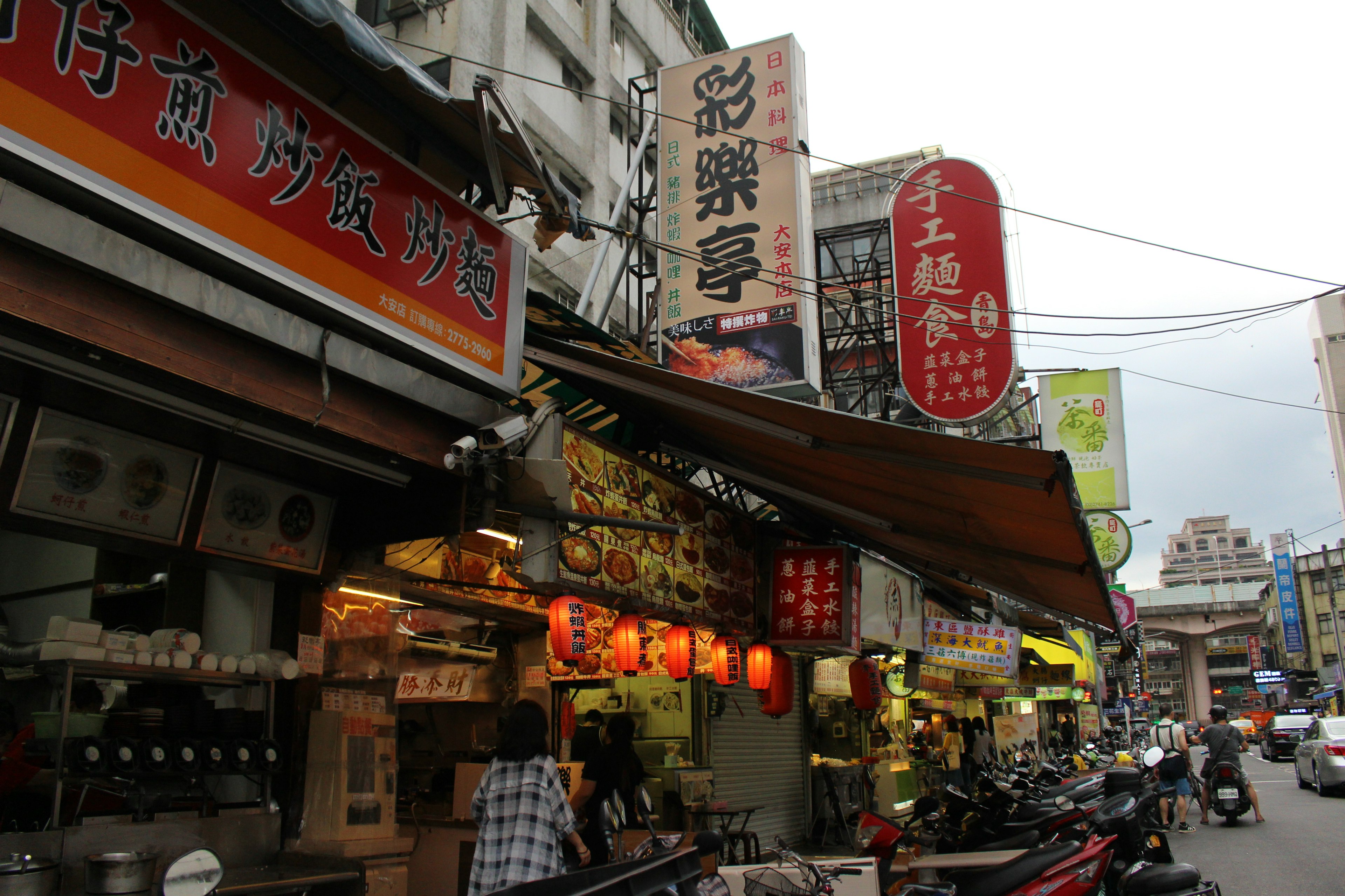 Puestos de comida callejera con letreros brillantes y ambiente animado