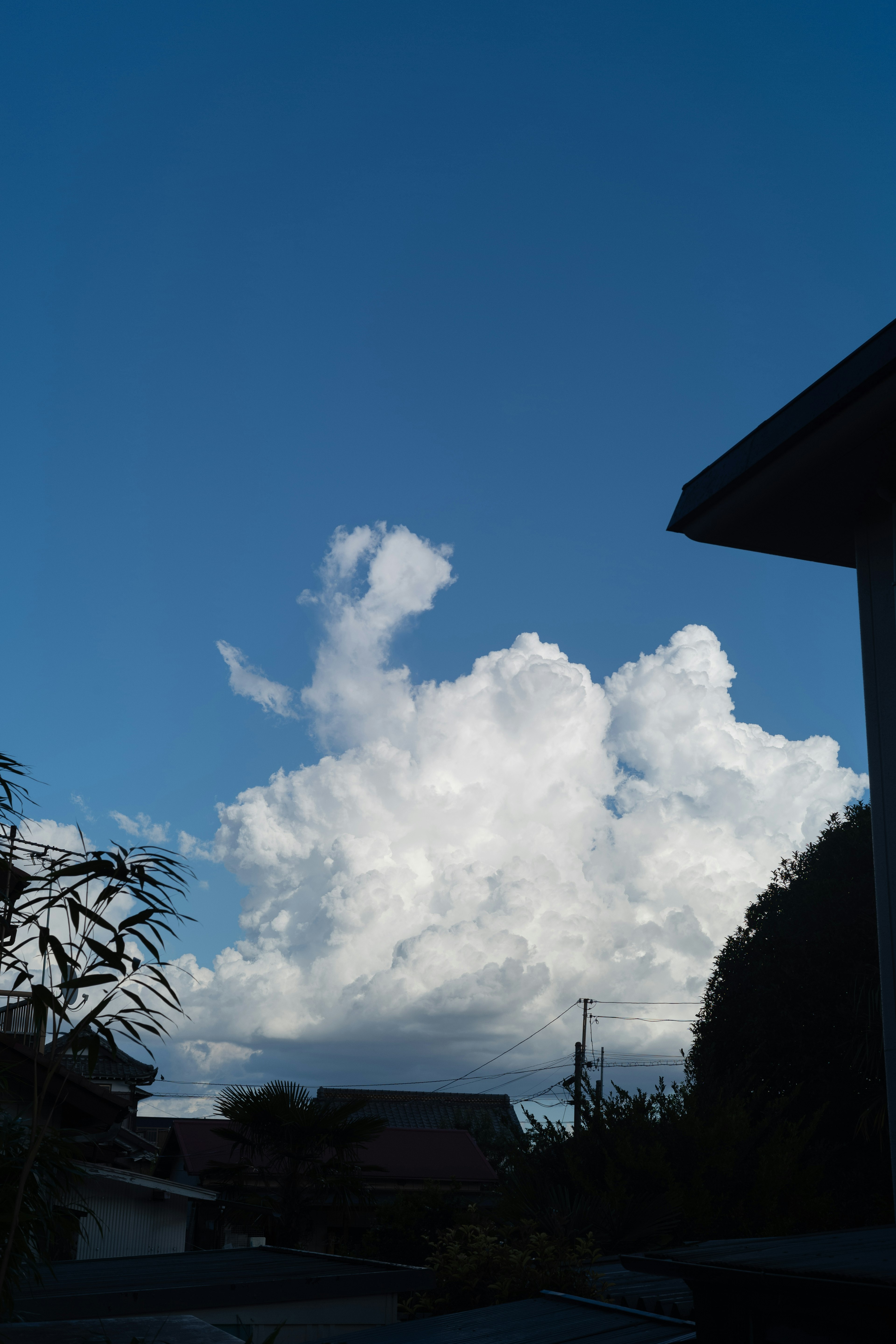 青空に浮かぶ白い雲と周囲の建物