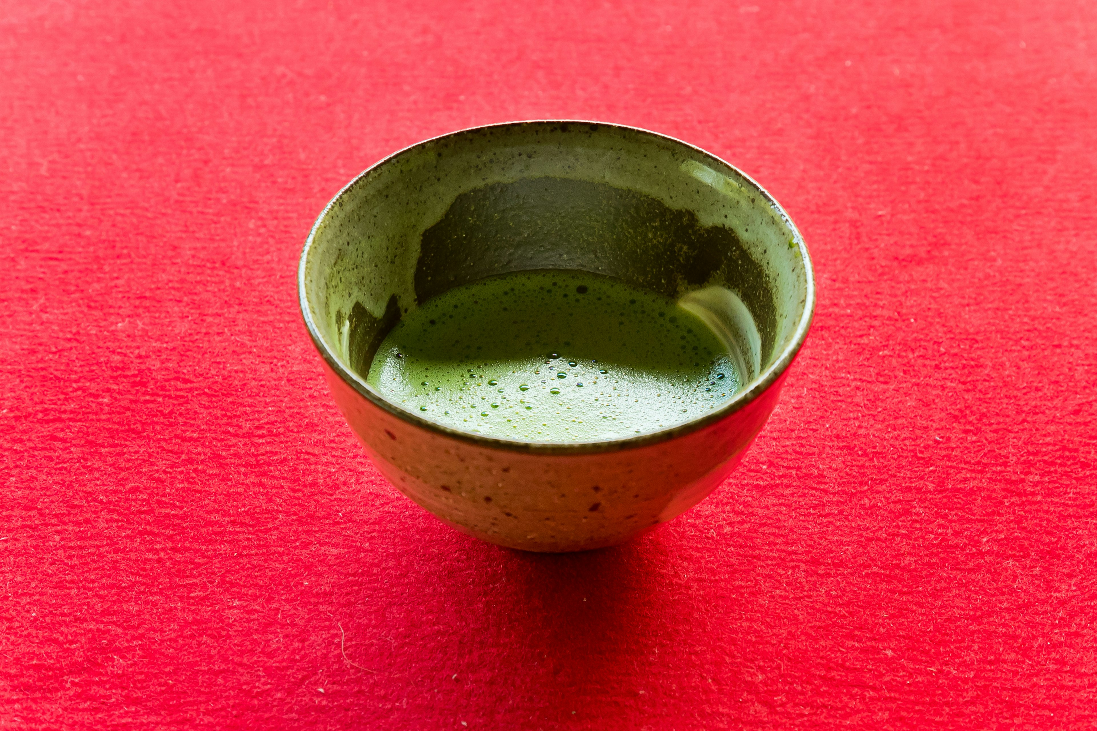 Cuenco de té verde sobre una tela roja