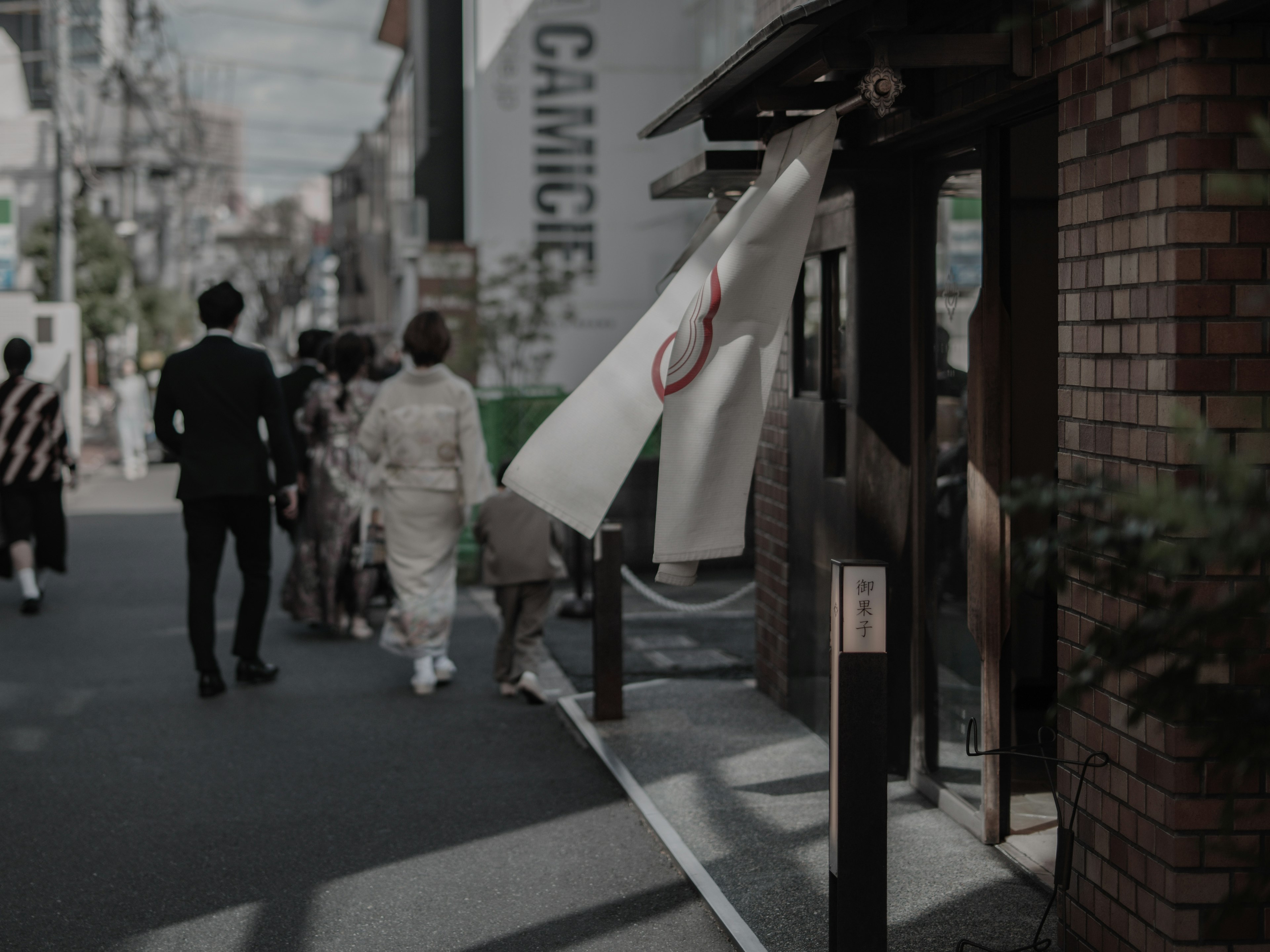 Scene of people lined up on the street with a flag swaying in the wind