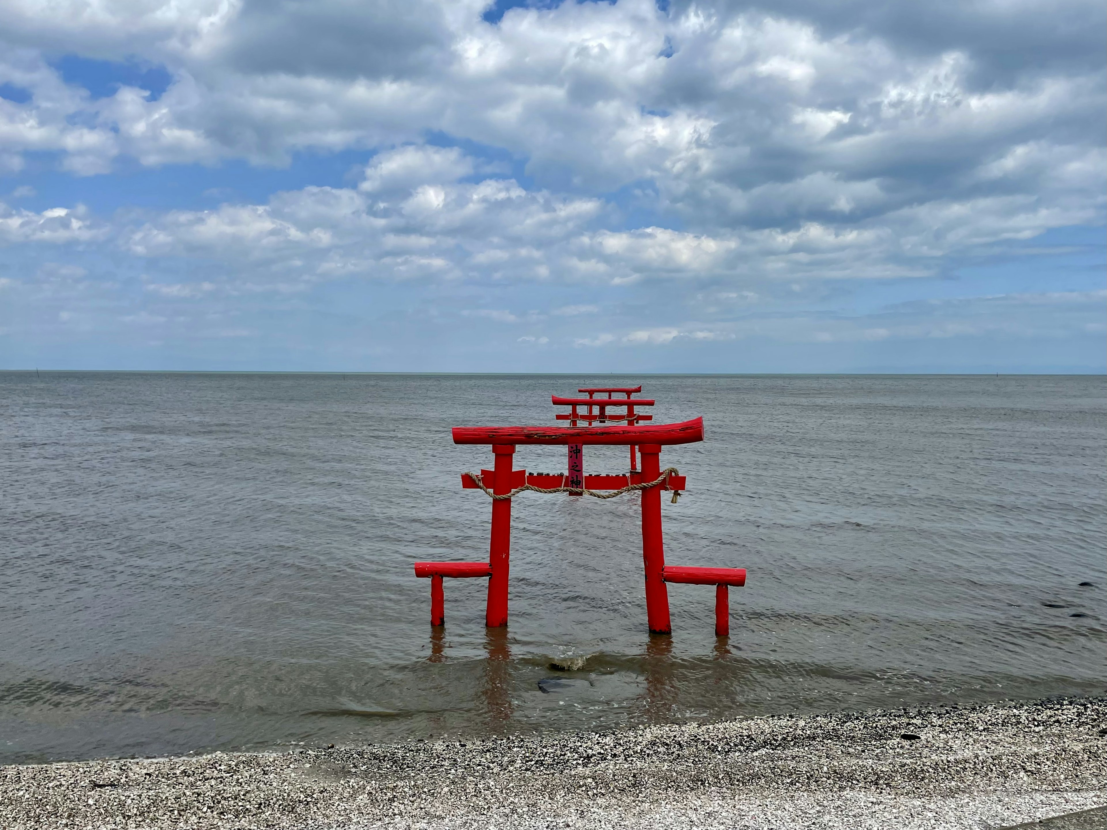 Una puerta torii roja de pie en el mar