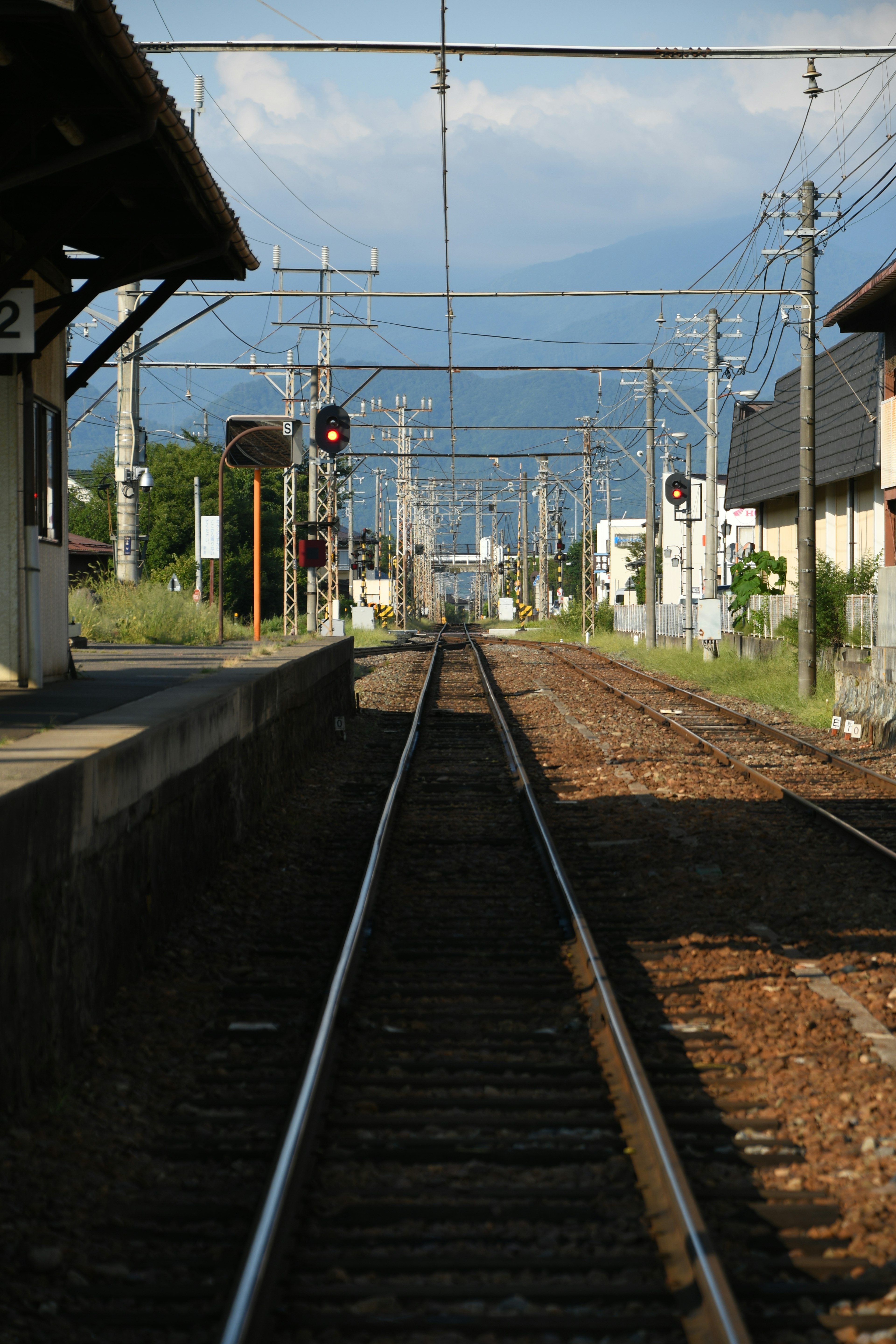 Voies de train d'une gare rurale tranquille avec des signaux