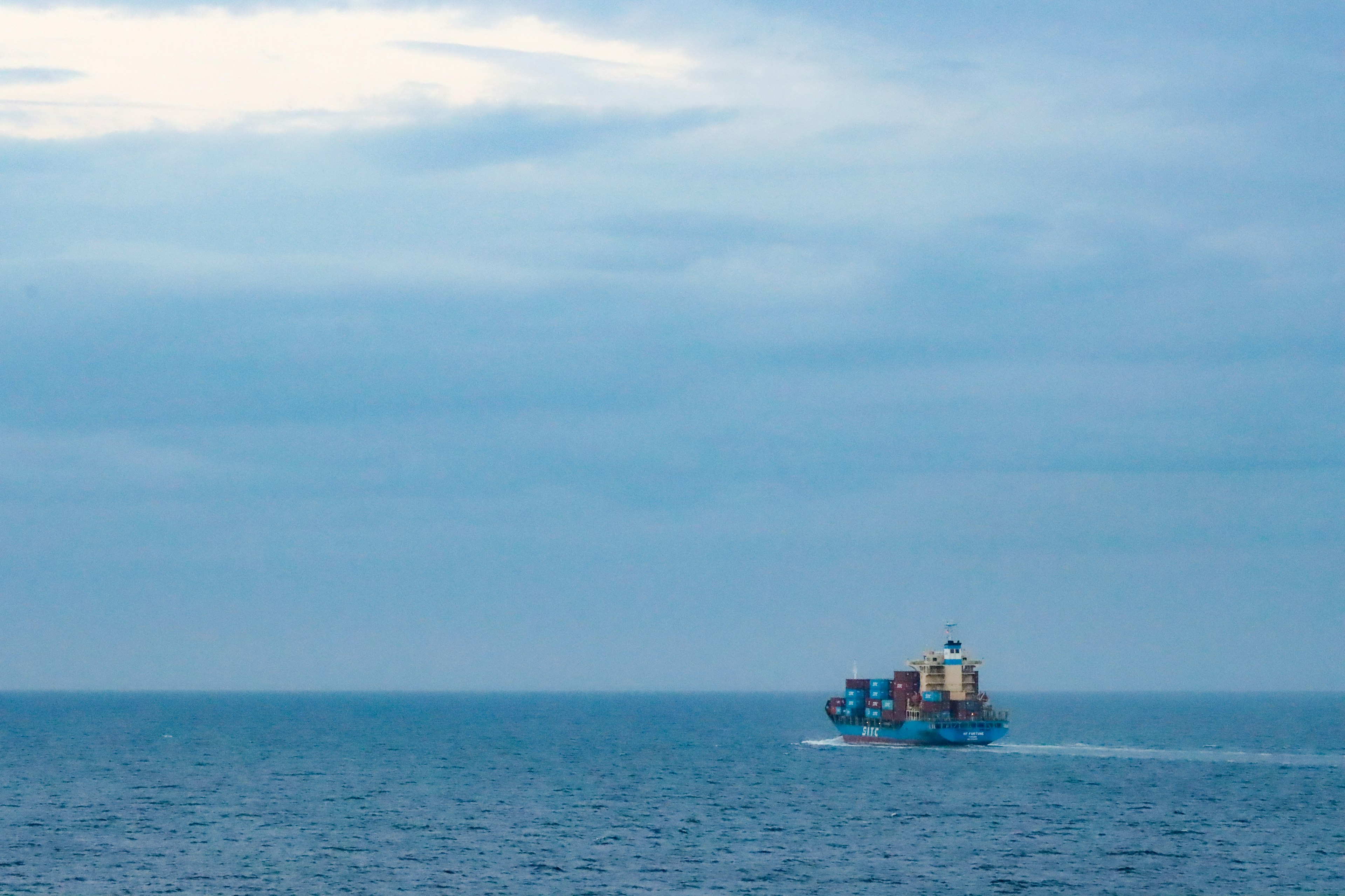 Un barco de carga colorido navegando en un mar azul