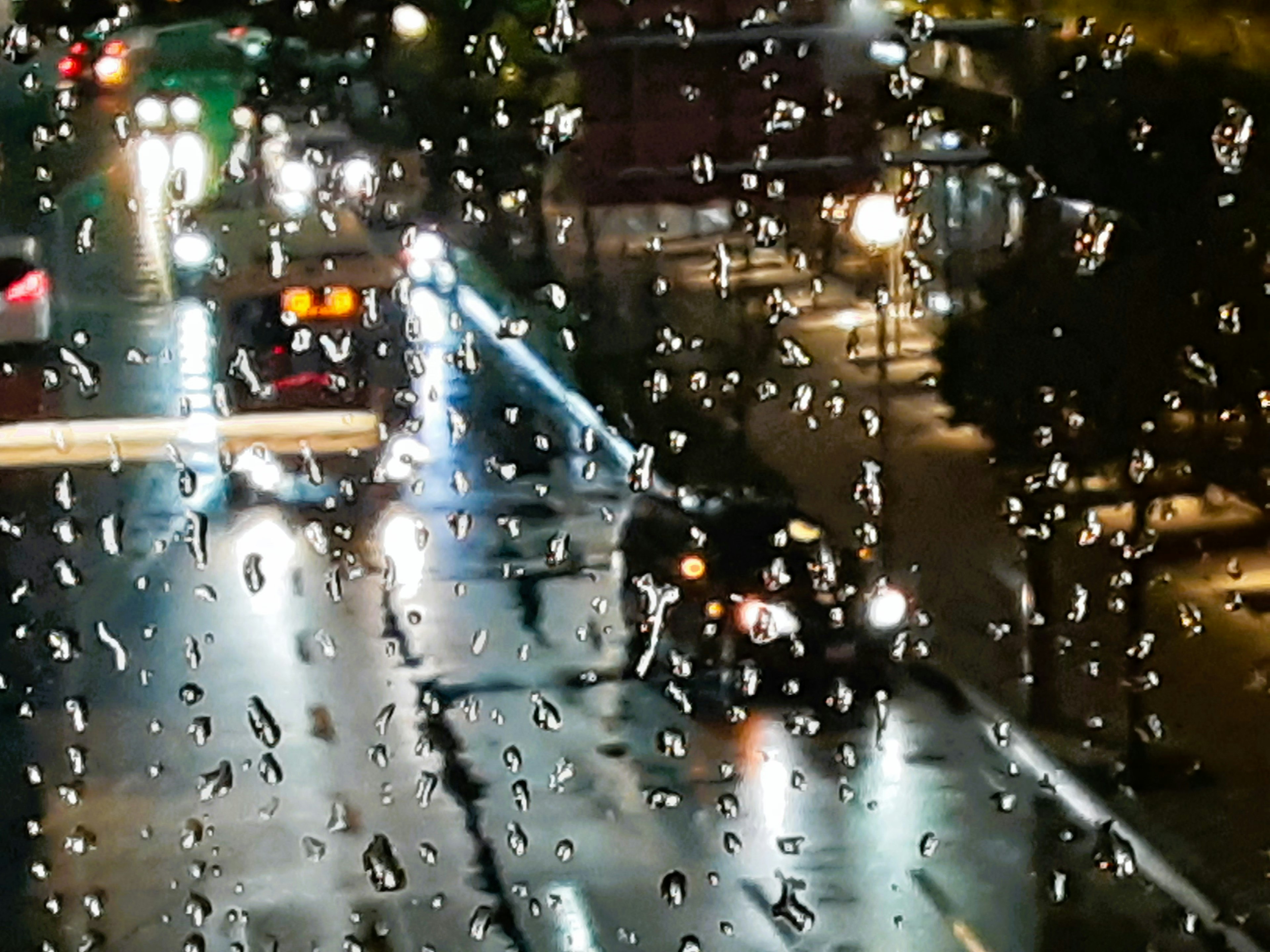 Night cityscape viewed through a rain-speckled window