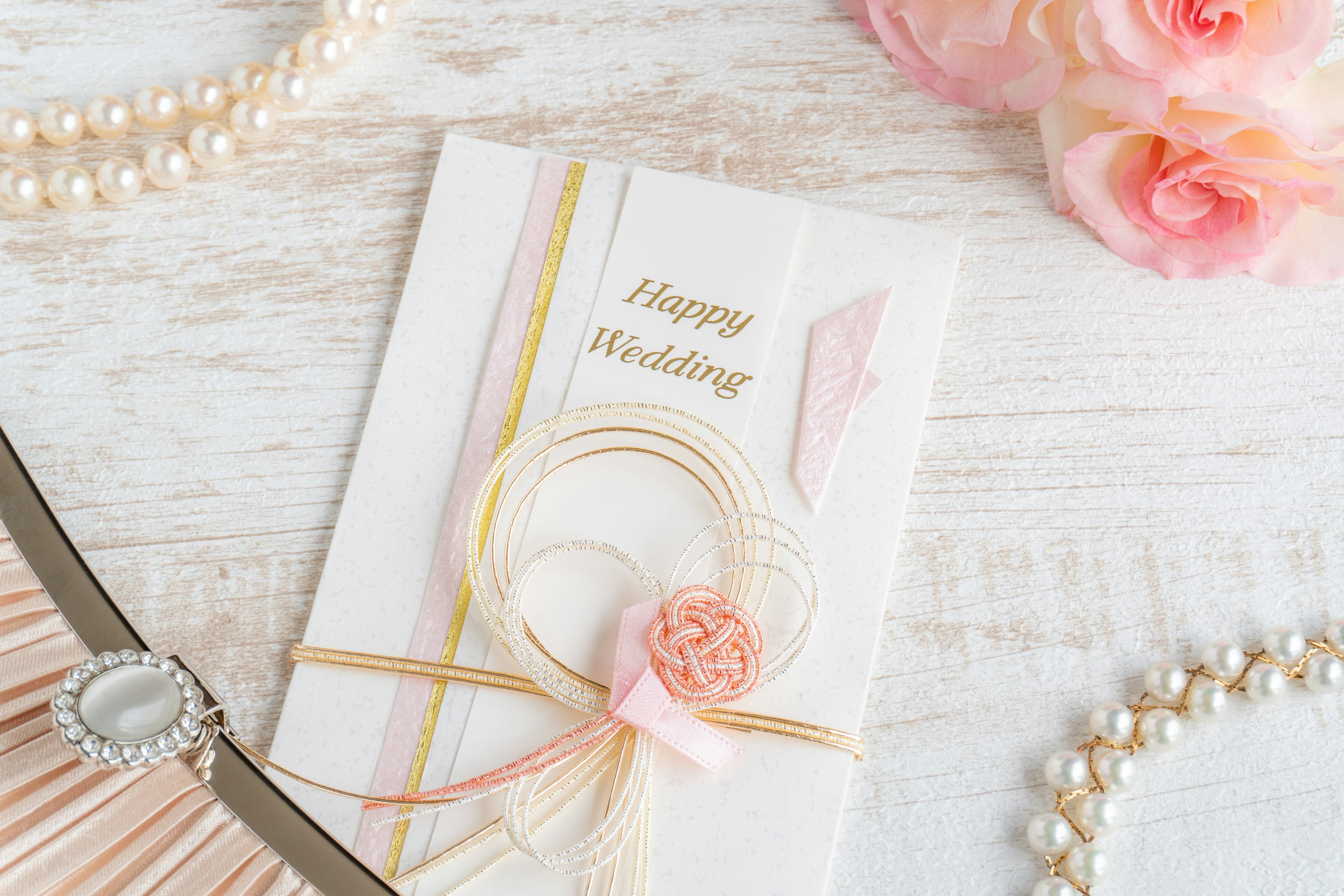 Elegant wedding invitation with ribbon and floral accents on a wooden table