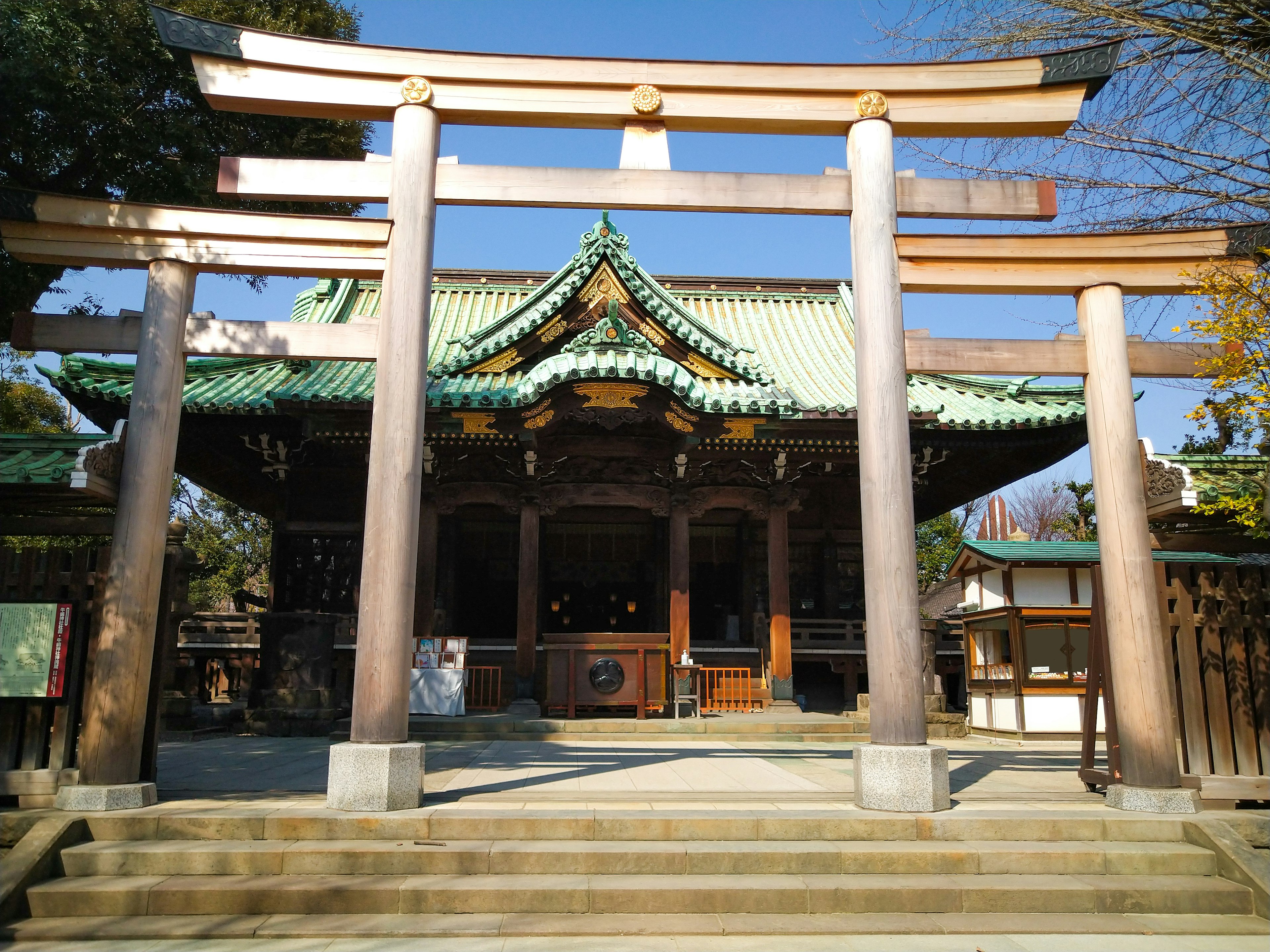 Kuil tradisional dengan gerbang torii di bawah langit biru