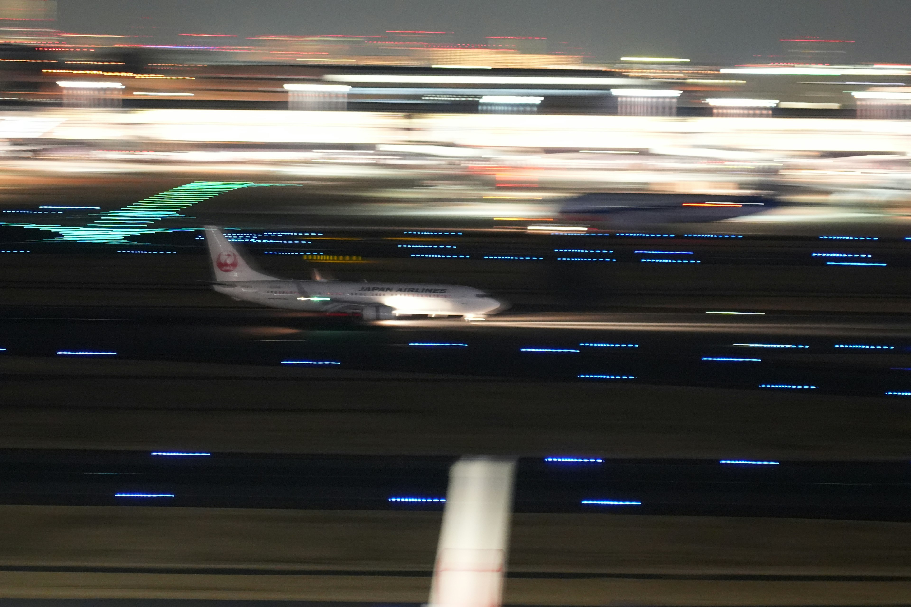 夜の滑走路を滑走する飛行機のぼやけた画像