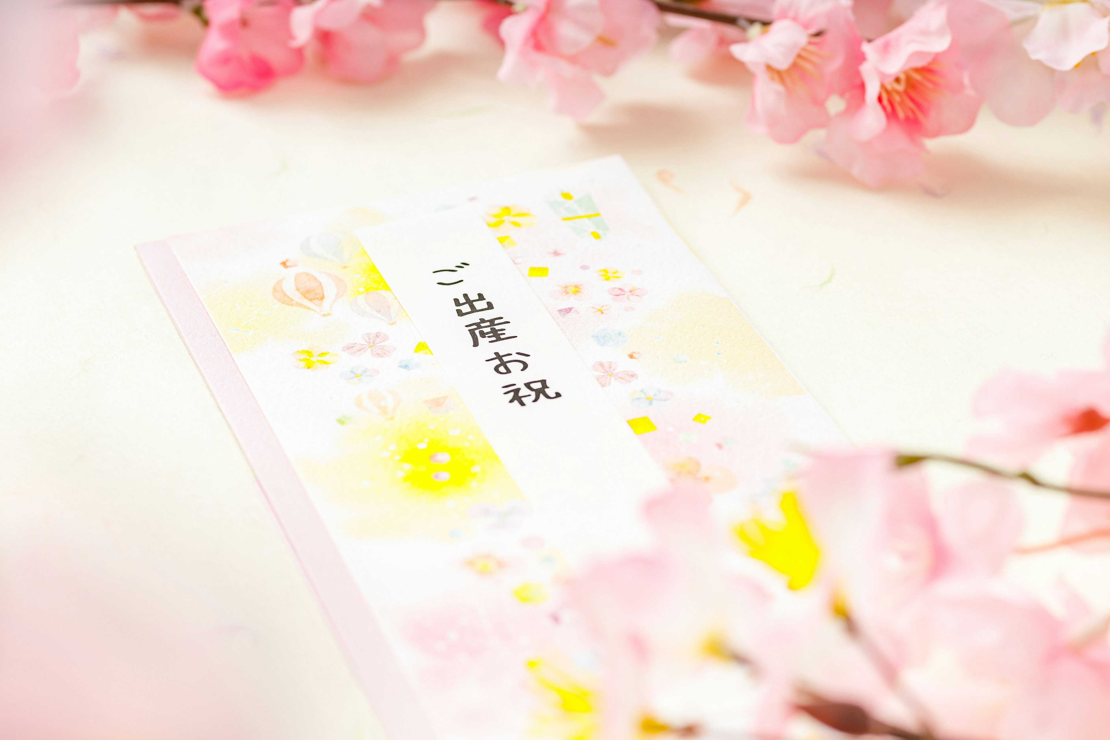 A cute card surrounded by pink cherry blossom petals