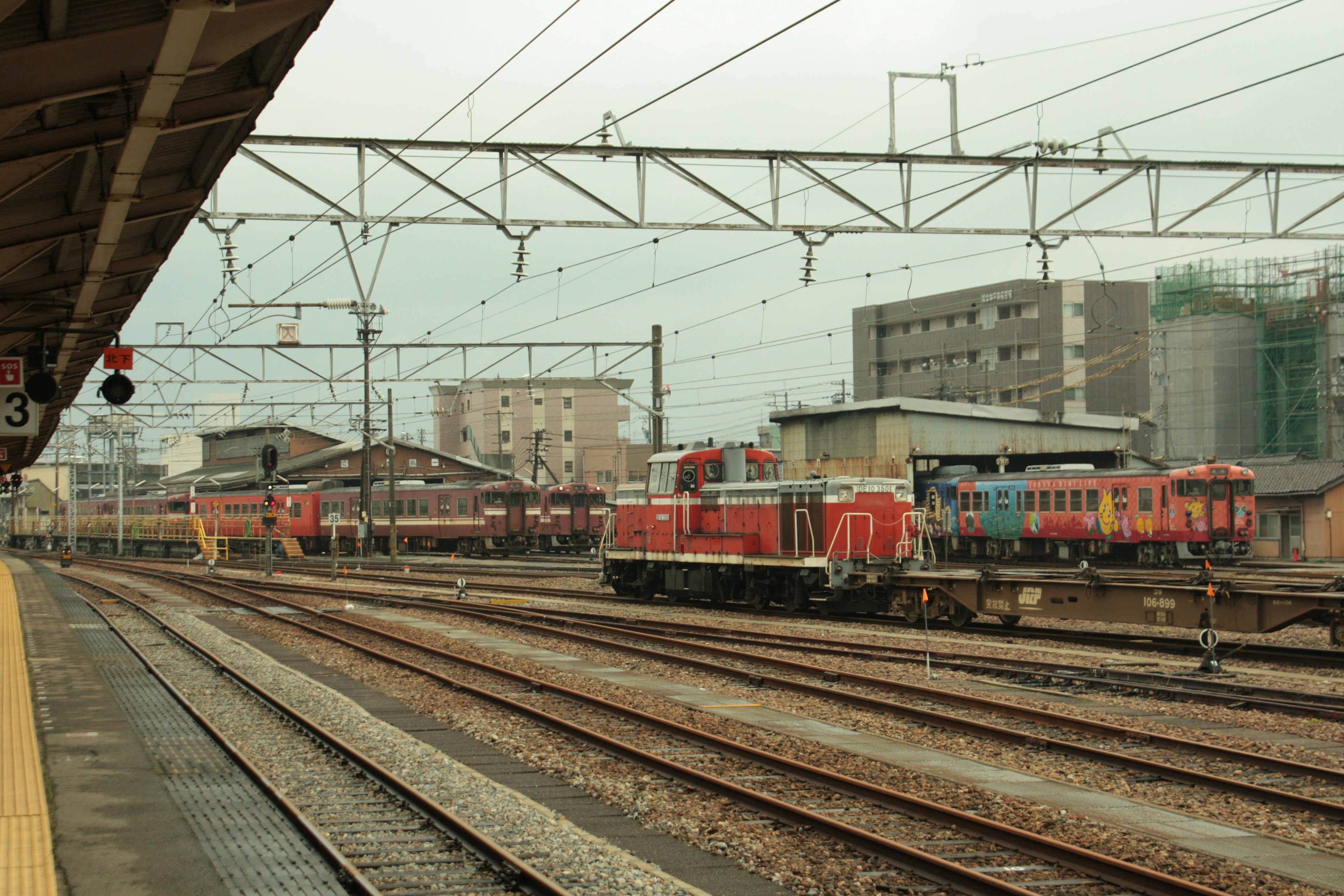 Blick auf mehrere Züge und Gleise von einem Bahnsteig