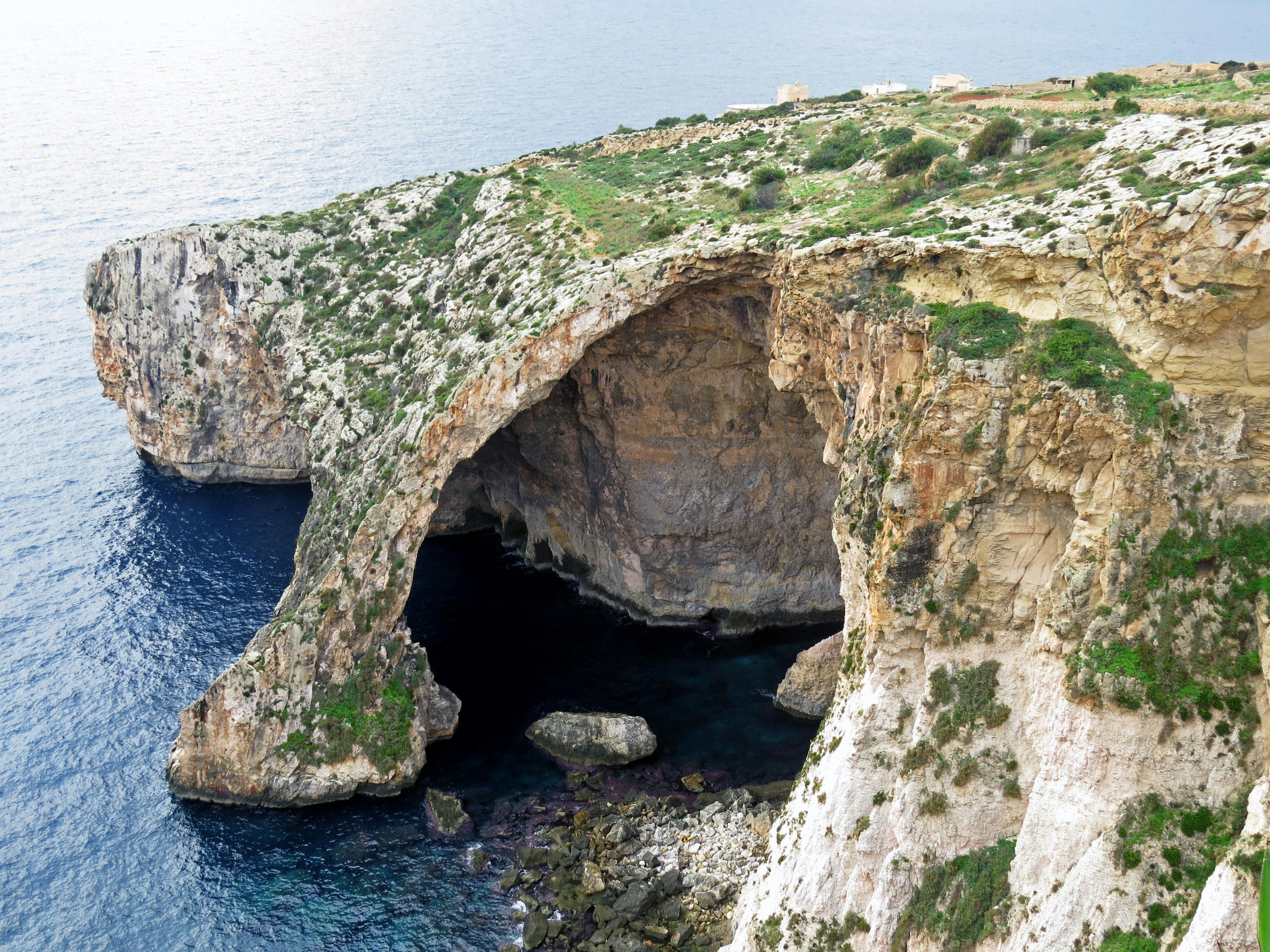 Vista panoramica di una scogliera rocciosa con vegetazione che sovrasta il mare