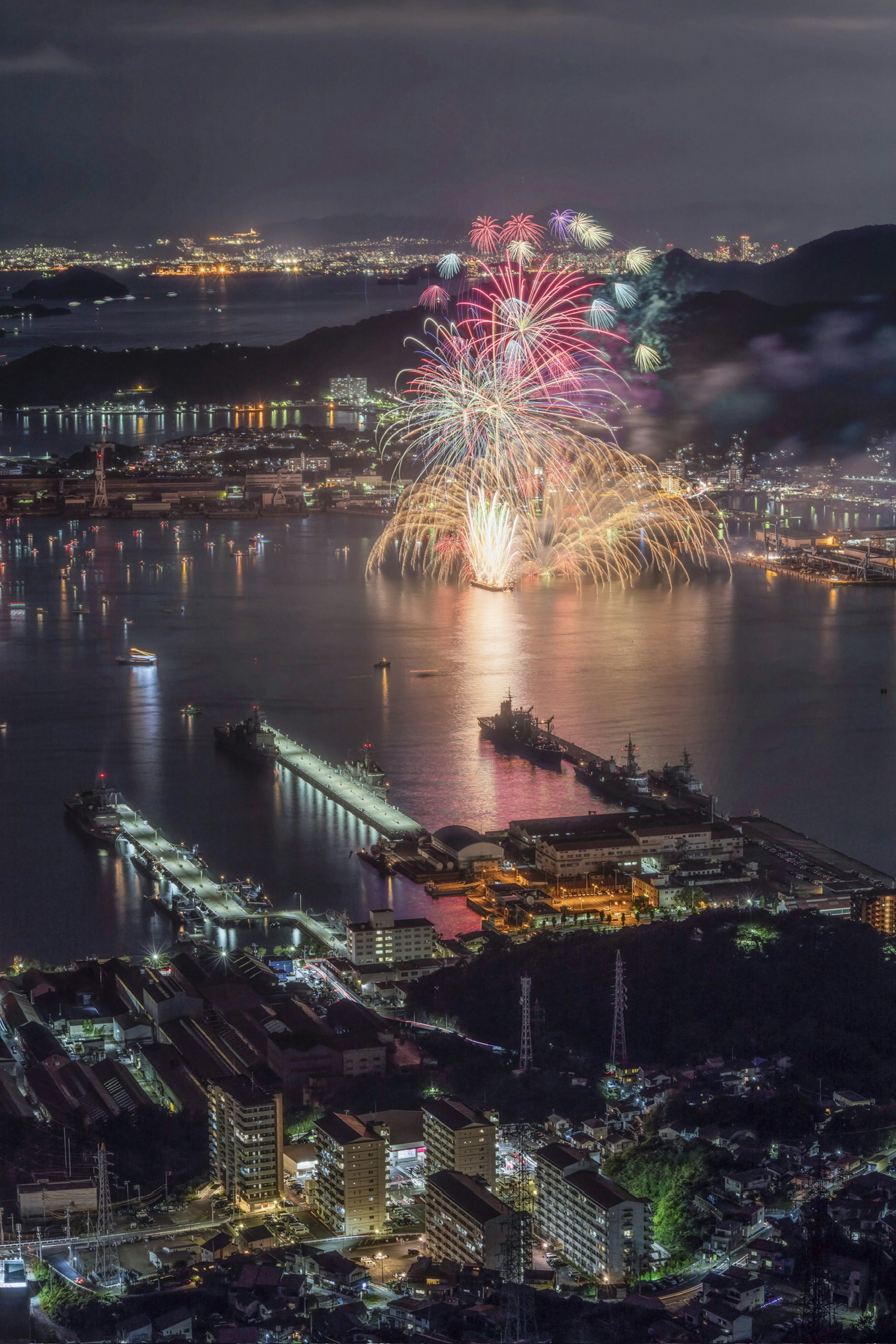 Belle vue de feux d'artifice se reflétant sur l'eau la nuit