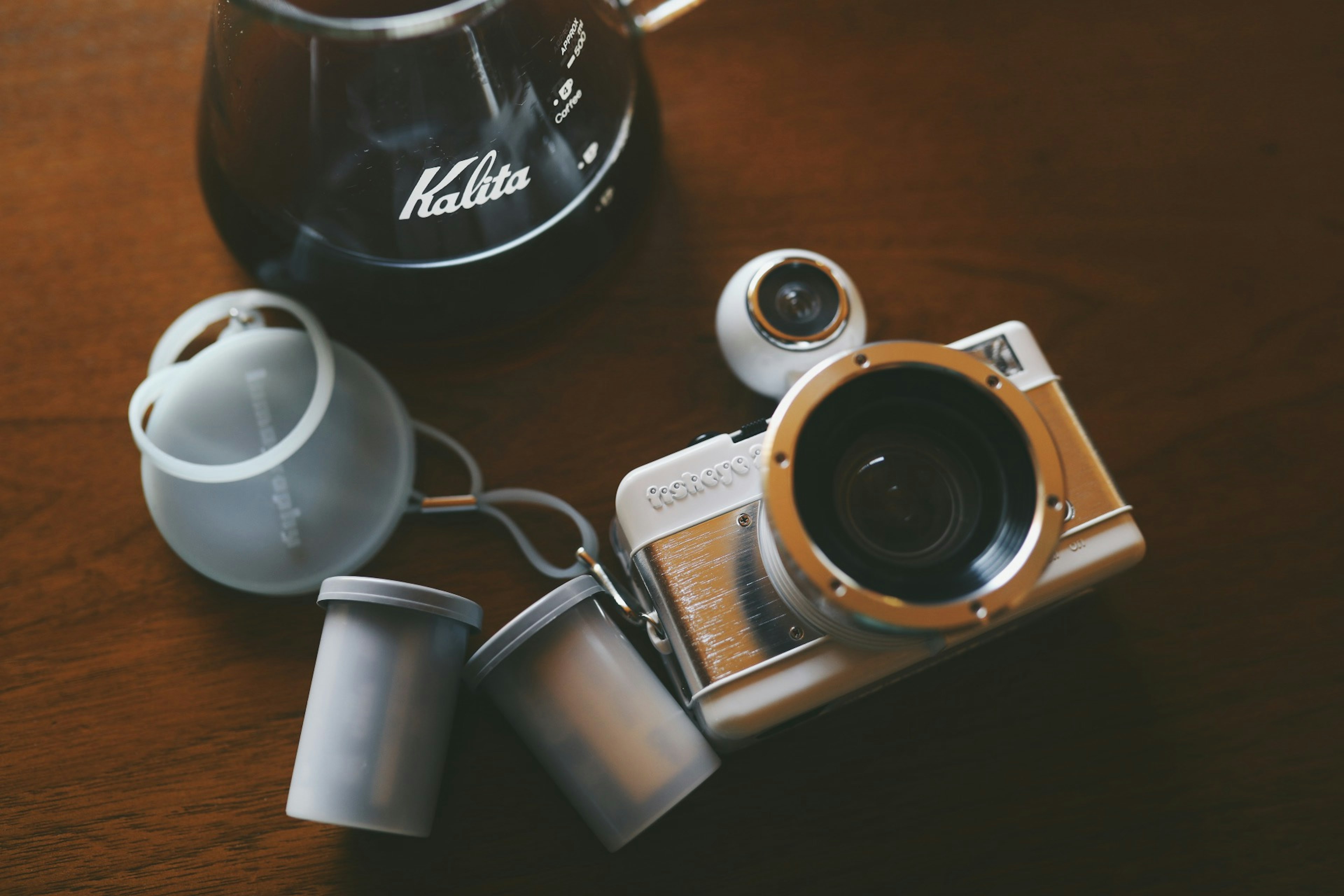 Scena di una macchina fotografica e attrezzatura da caffè su un tavolo di legno