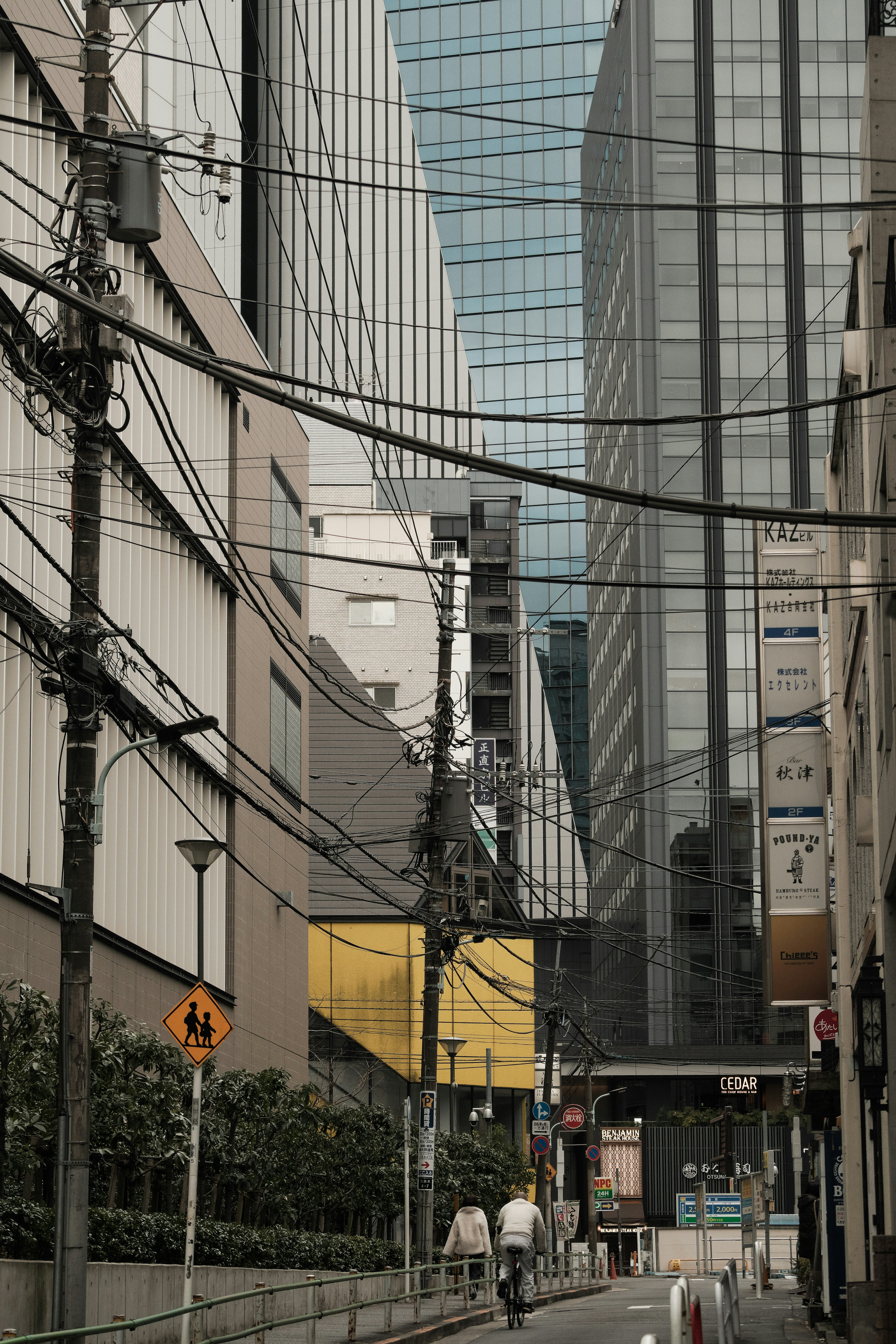 Escena de calle urbana con edificios altos y líneas eléctricas