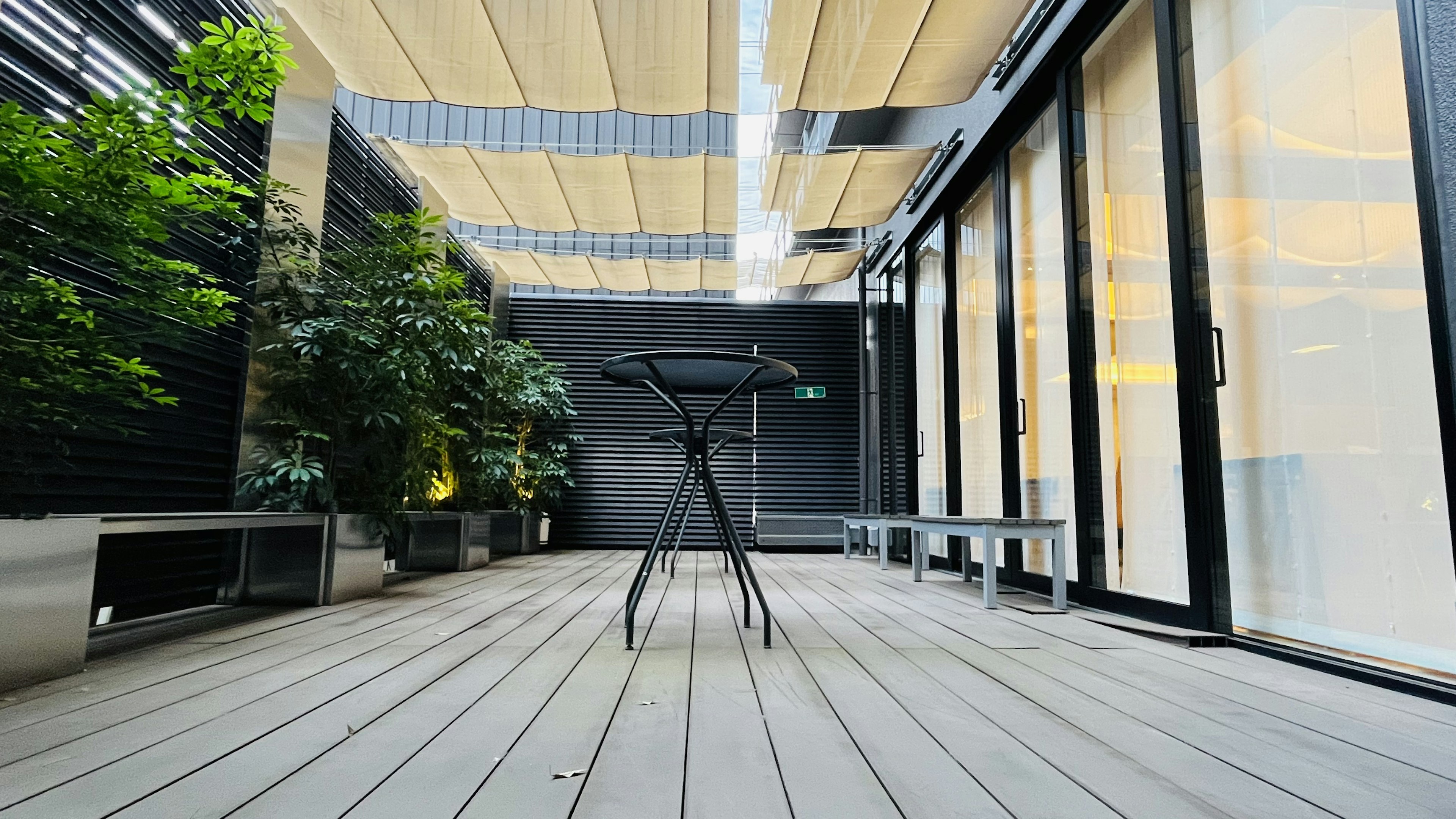 Moderner Balkon mit einem schwarzen Tisch und Pflanzen