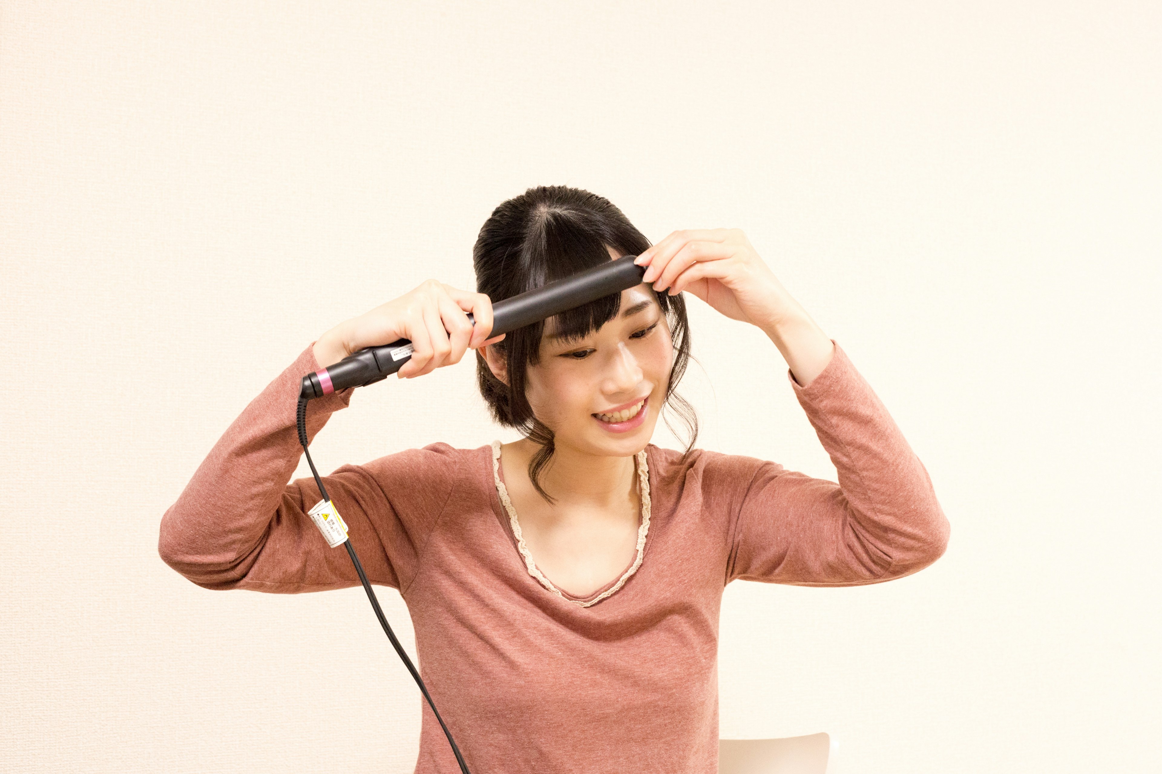 Woman styling her hair with a flat iron