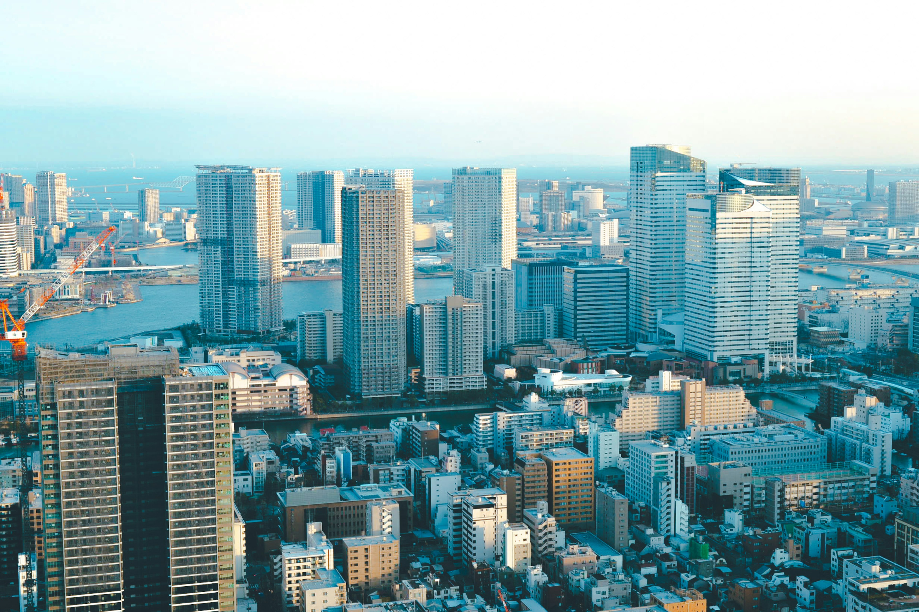 高層ビルが立ち並ぶ都市の風景 青い空と水面が見える