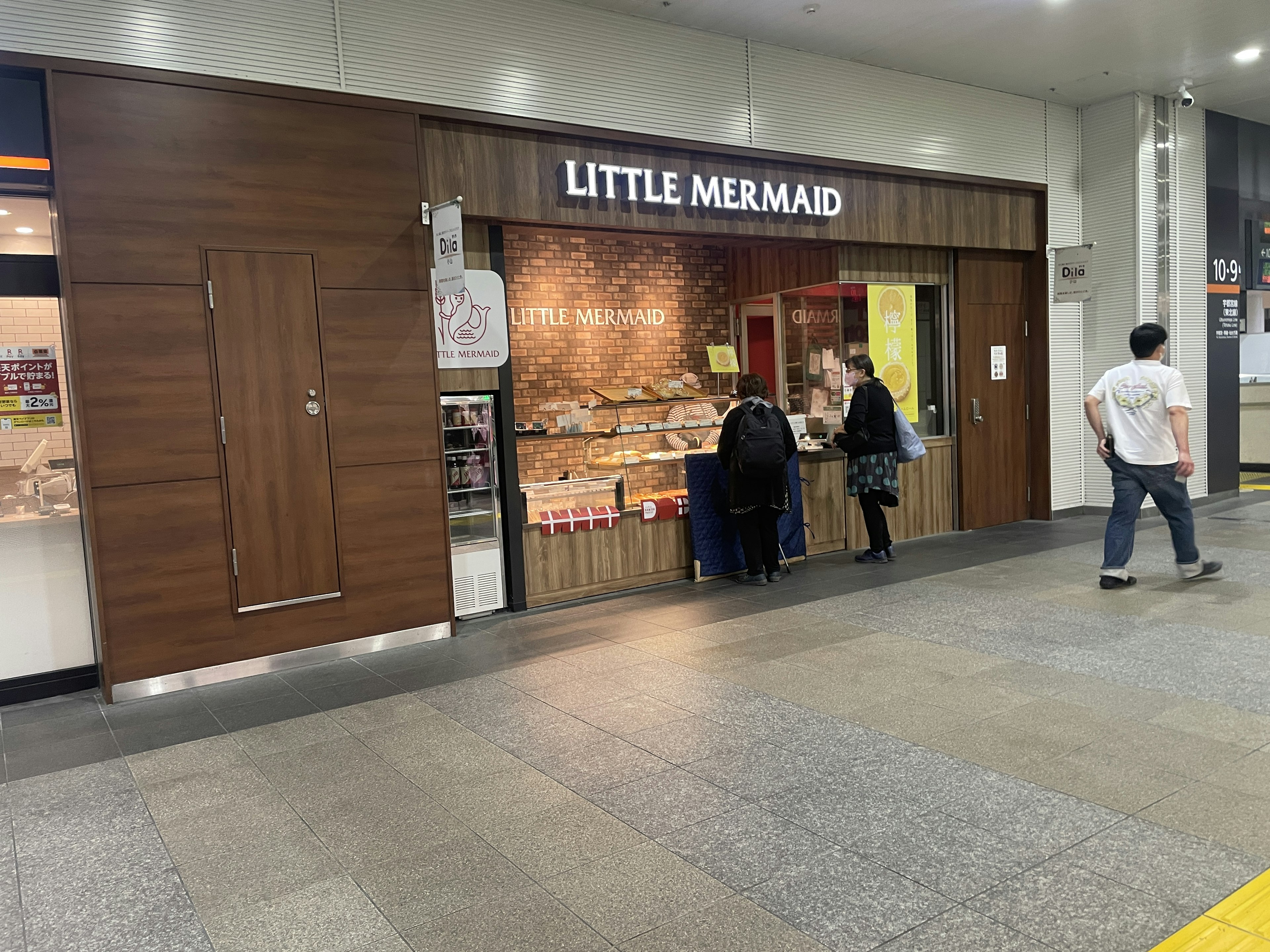 Exterior of Little Mermaid bakery with customers ordering