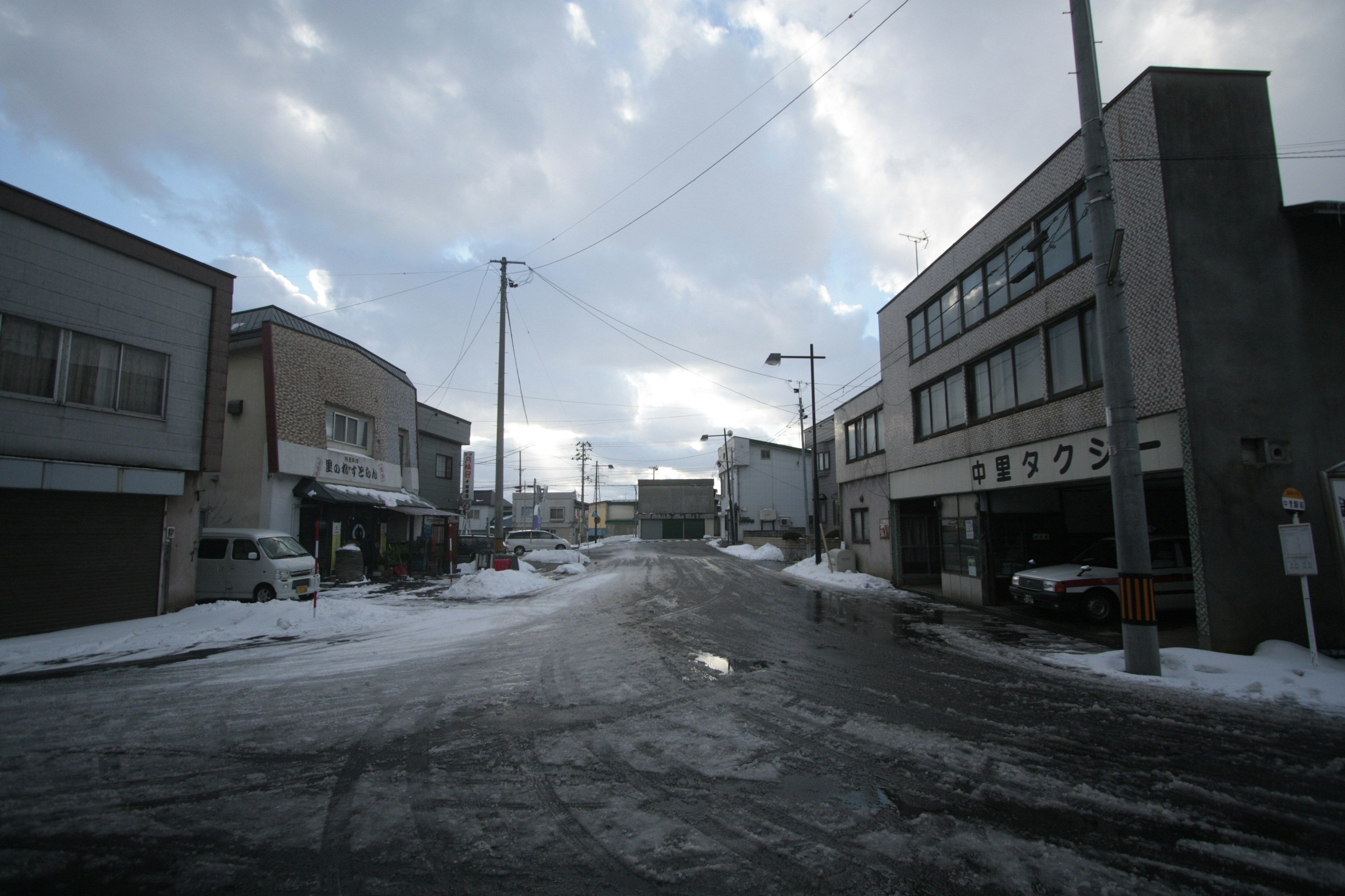 Scena di angolo di strada innevata con edifici e cielo