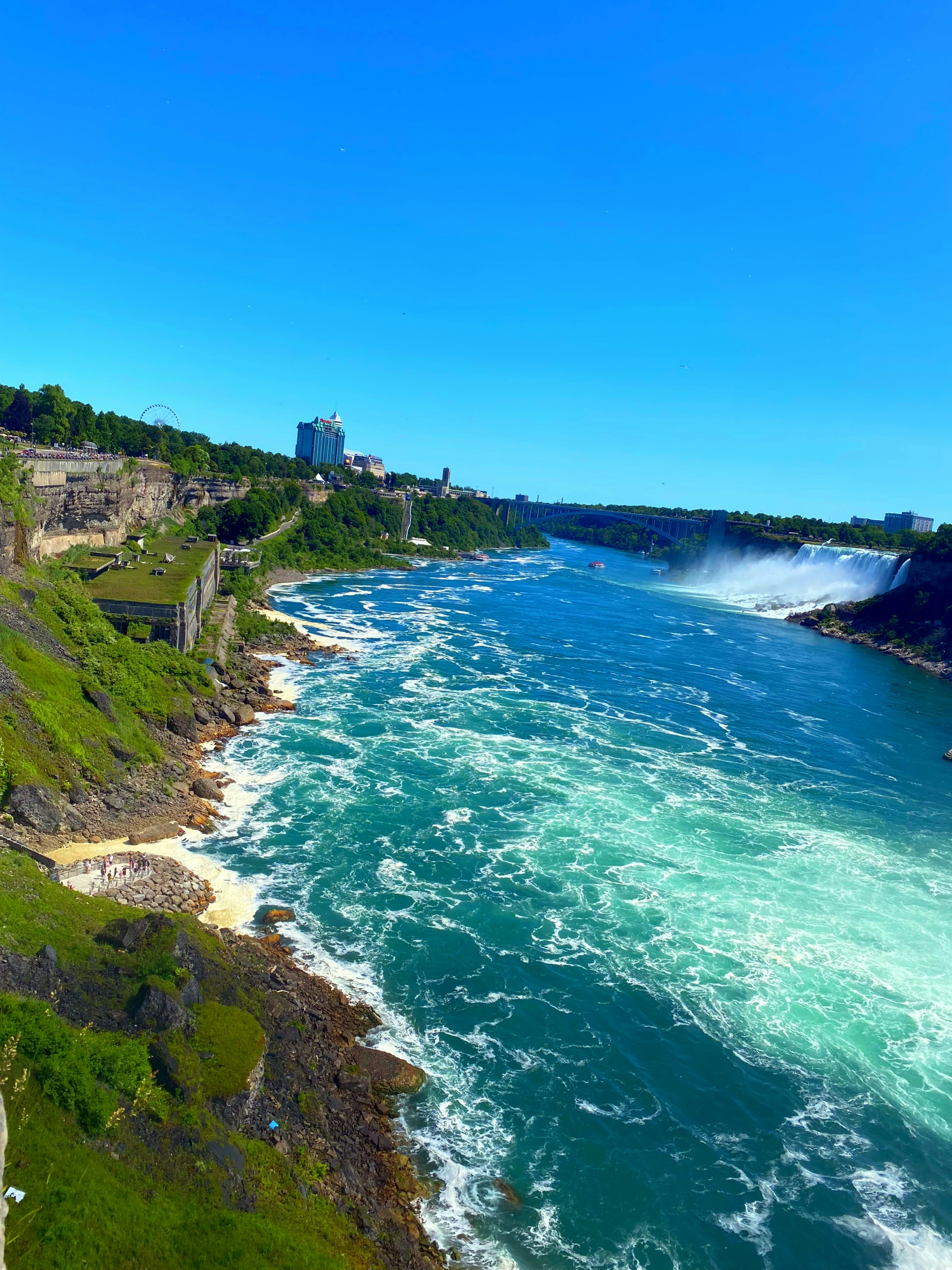 Malersicher Blick auf den Niagarafluss mit üppigen grünen Ufern und klarem blauen Himmel