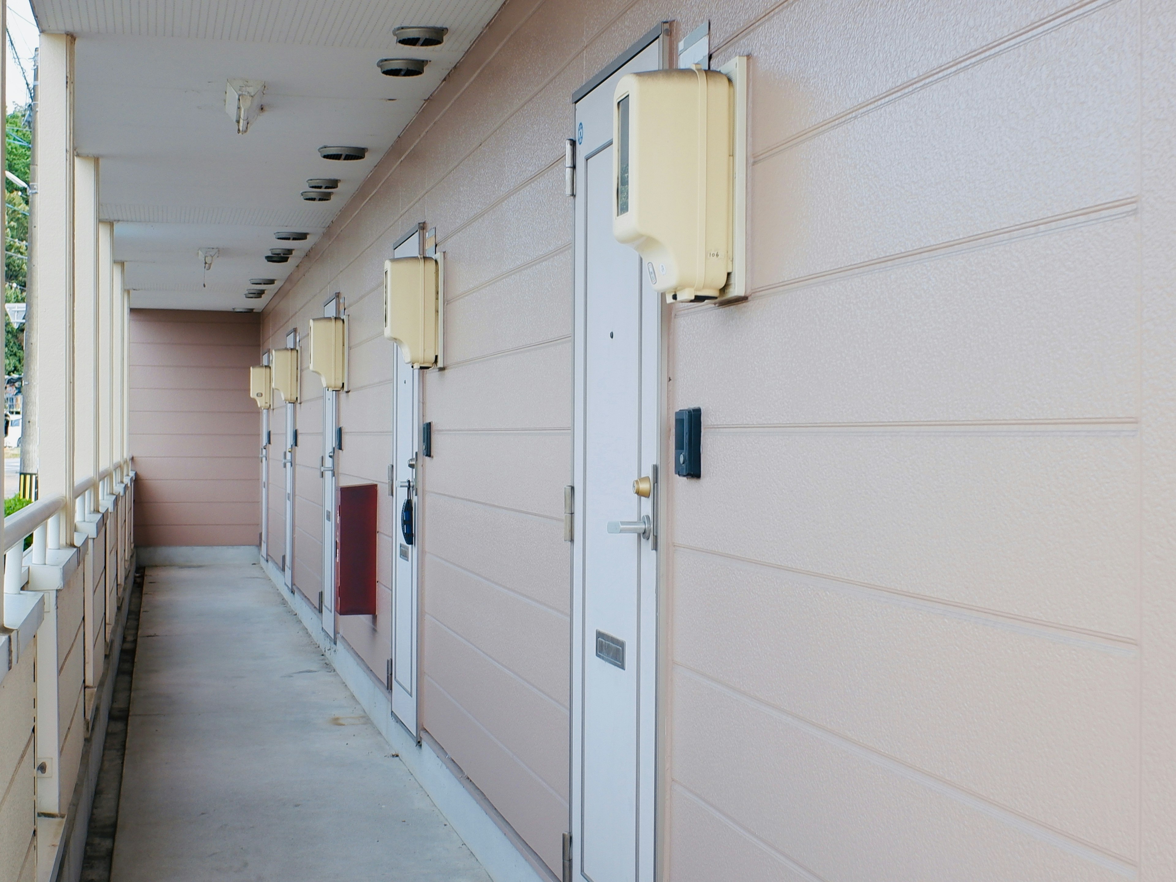 Imagen de un corredor de apartamento con múltiples puertas y paredes de color claro