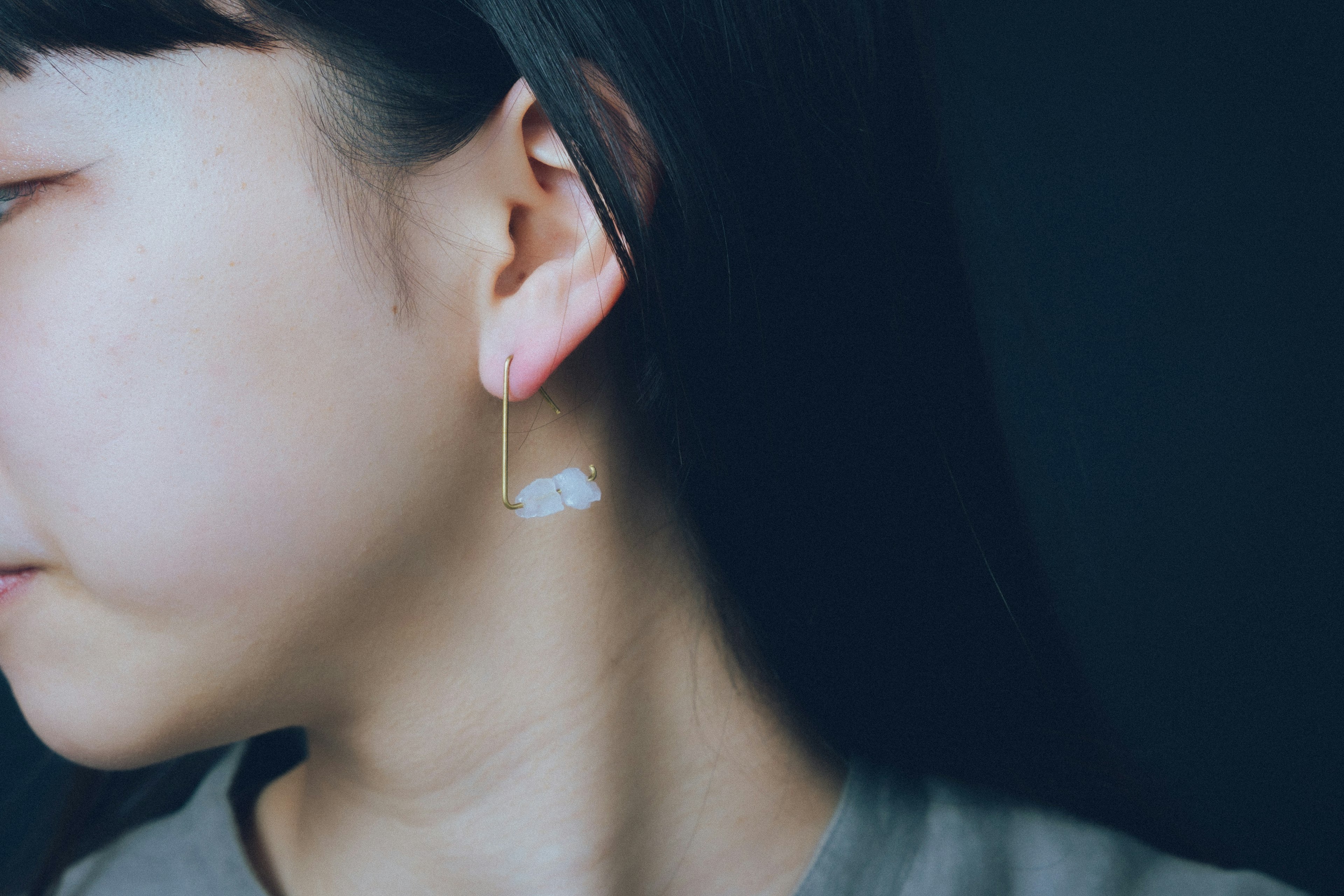 Close-up of a woman wearing cloud-shaped earrings