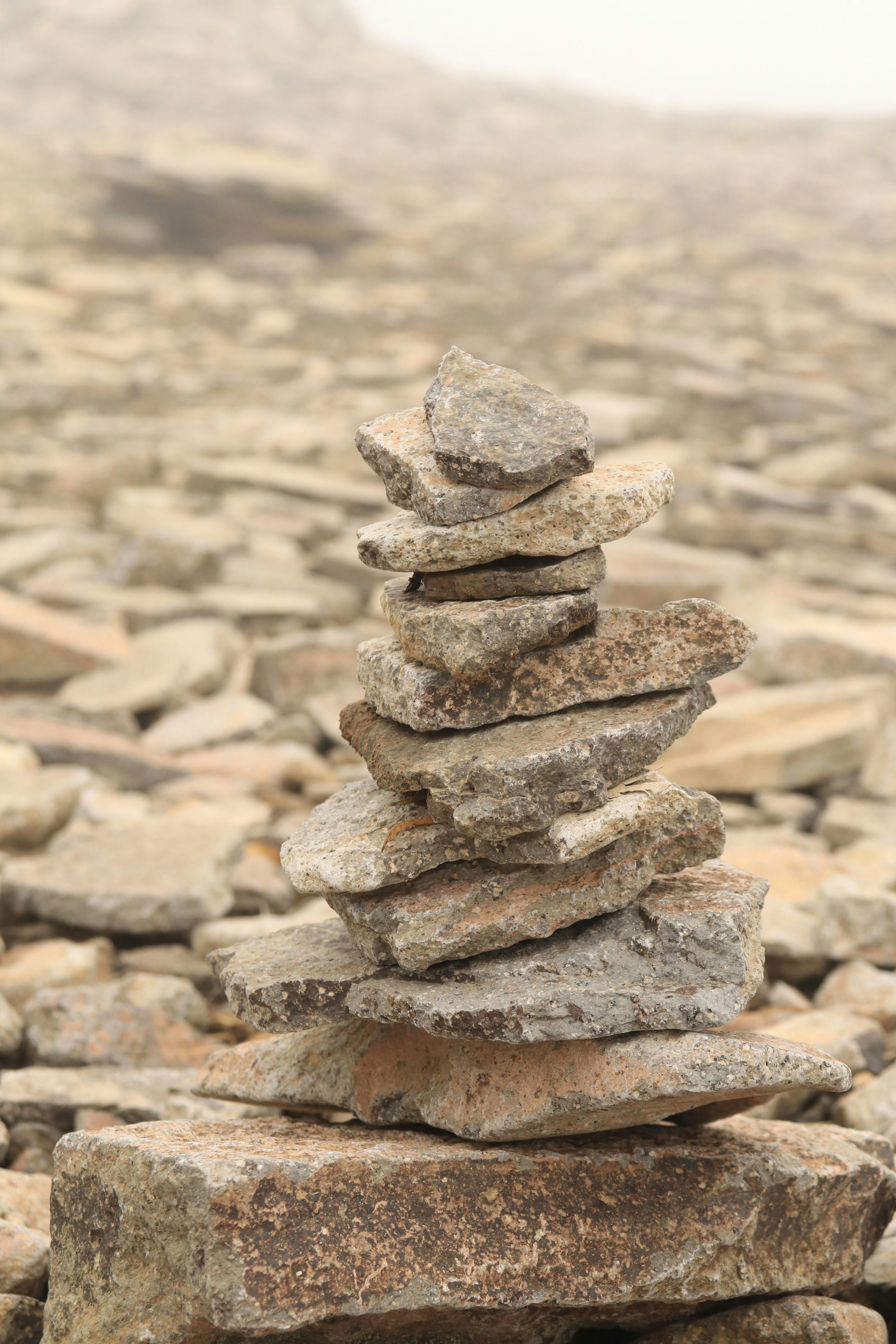 Una torre de piedras apiladas con un paisaje rocoso de fondo