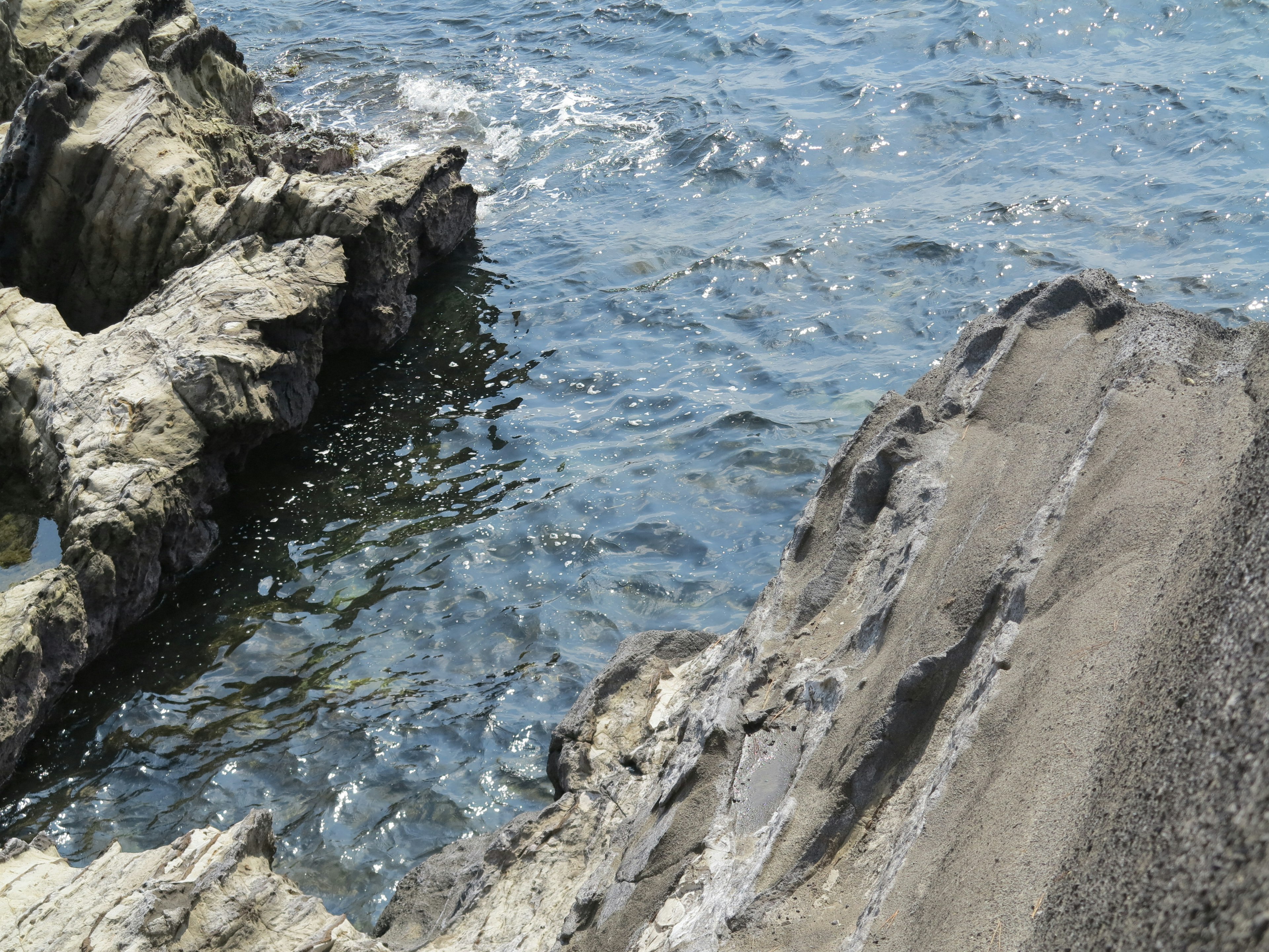 Partial view of rocks meeting ocean water